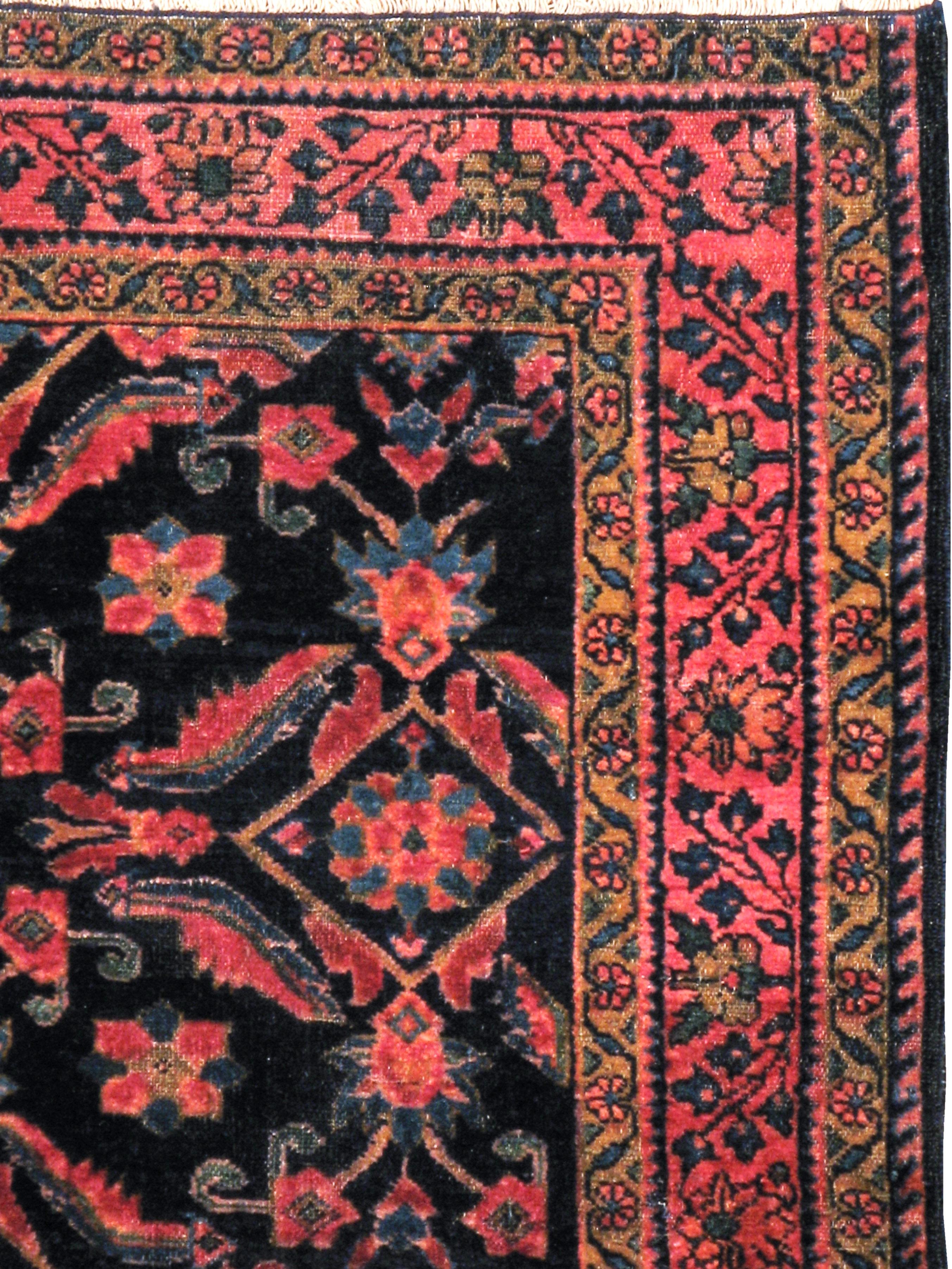 An antique Persian Lilihan rug from the early 20th century. This small squarish Hamadan area rug displays a large scale, spacious Herati design on a black and navy blue field somewhat reminiscent of the Turkish Oushak Yaprak design. The narrow rose