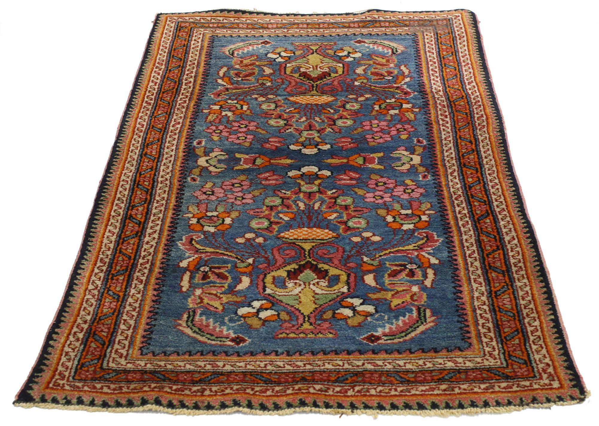 77073, an antique Lilihan rug with vase motif. This luxurious hand-knotted wool antique Persian Lilihan rug features a double vase design on an abrashed field dotted with cherry pink flowers and a compound tribal patterned band. Rendered in a