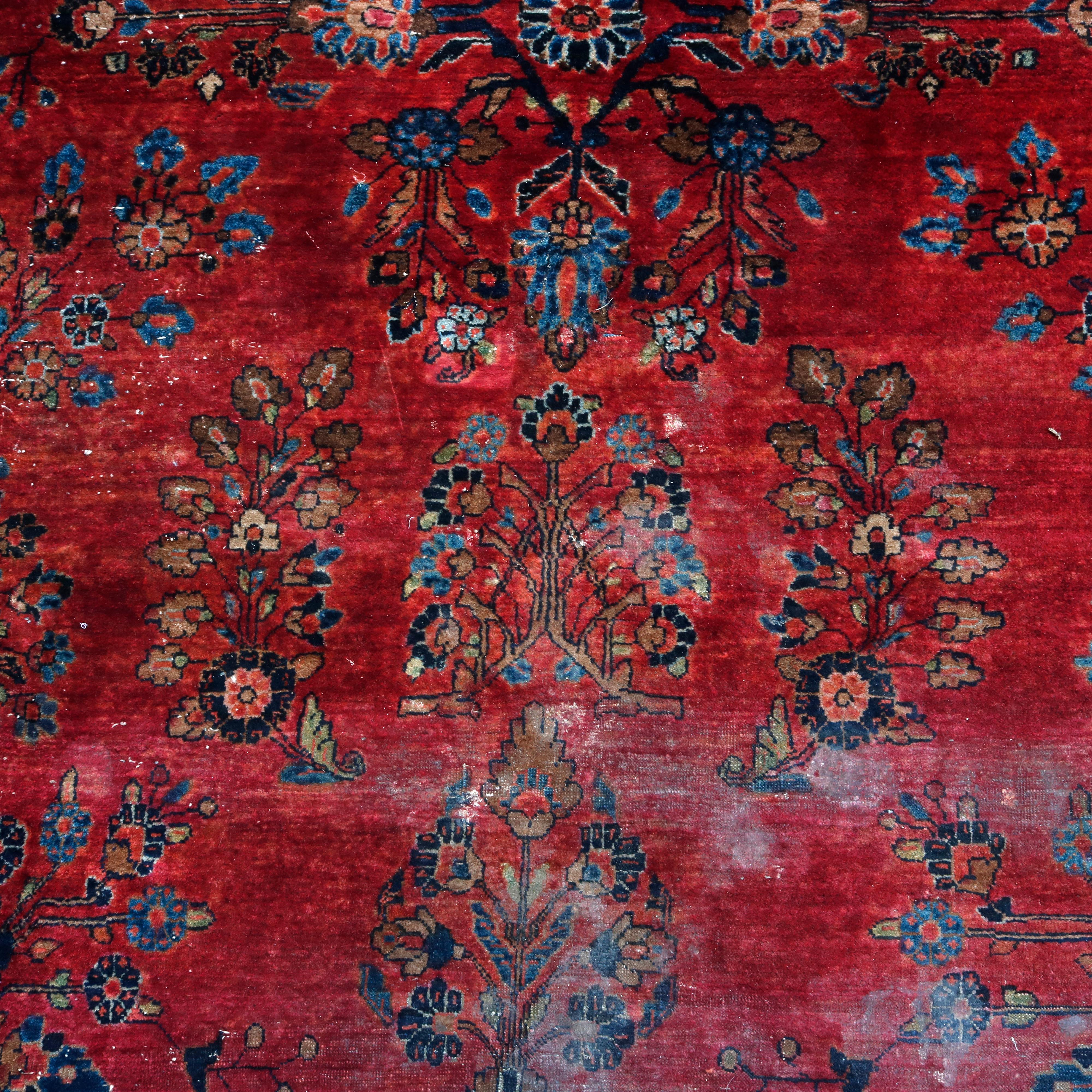 An antique Persian Mahajeran Sarouk oriental rug offers wool construction with central floral medallion and all-over floral and foliate design on red ground, circa 1920

Measures: 71.5