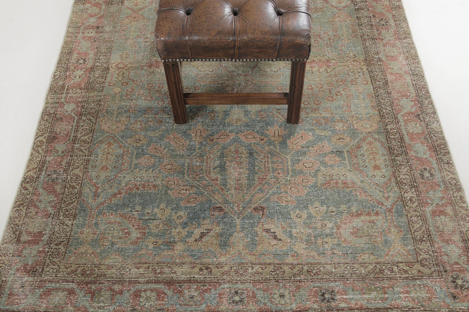 A beguiling Antique Persian Mahal rug that emanates a balanced and timeless floral design with a patina that is beautifully timeworn. The abrashed turquoise field is covered with an all-over botanical pattern composed of blooming palmettes, serrated