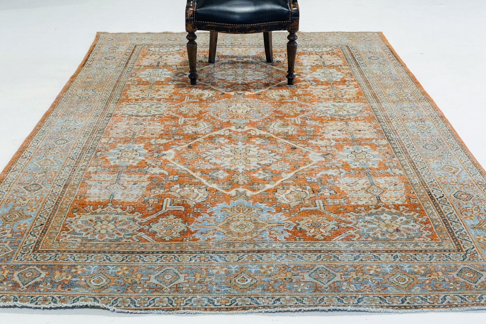 This antique Persian Mahal is the epitome of luxury. A series of ornate borders frames the piece, with geometric patterns being dominant. Within the field, an elegant and classical all-over pattern of flowering vine scrolls unfolds, the drawing of