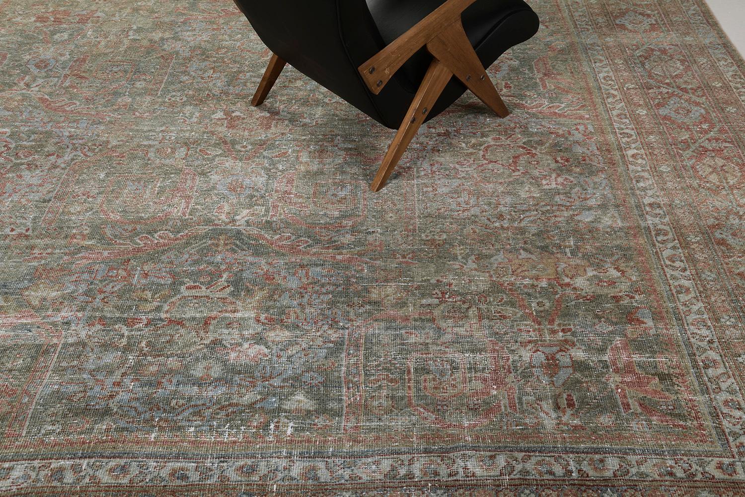 Ein exquisiter antiker persischer Mahal-Teppich, der sich durch zeitlose Anmut und nostalgischen Reiz auszeichnet. Dieser bezaubernde Teppich ist mit einer botanischen Bordüre umgeben, die von inneren und äußeren Schutzbändern flankiert wird. Das