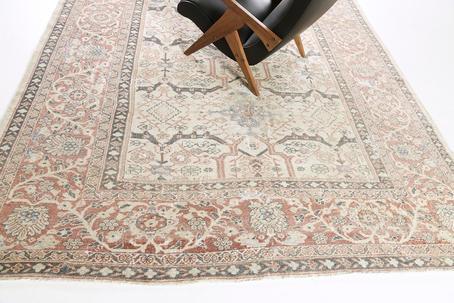 A fabulous antique Persian Mahal that features its dazzling design. Focused on its allover composition of botanical motifs, this majestic rug features the warm and aesthetic tones of ivory, terracotta, and aegean blue accents. The attention to