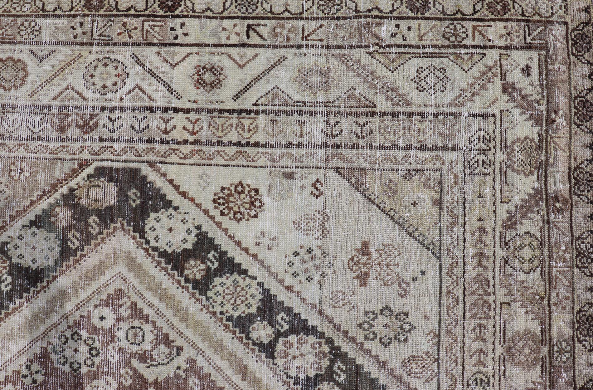 Questo antico tappeto persiano Mahal è stato annodato a mano in lana e presenta un disegno a medaglioni sub-geometrici multicolore. Un bordo complementare e a più livelli abbraccia l'intero pezzo, rendendolo adatto a un'ampia varietà di
