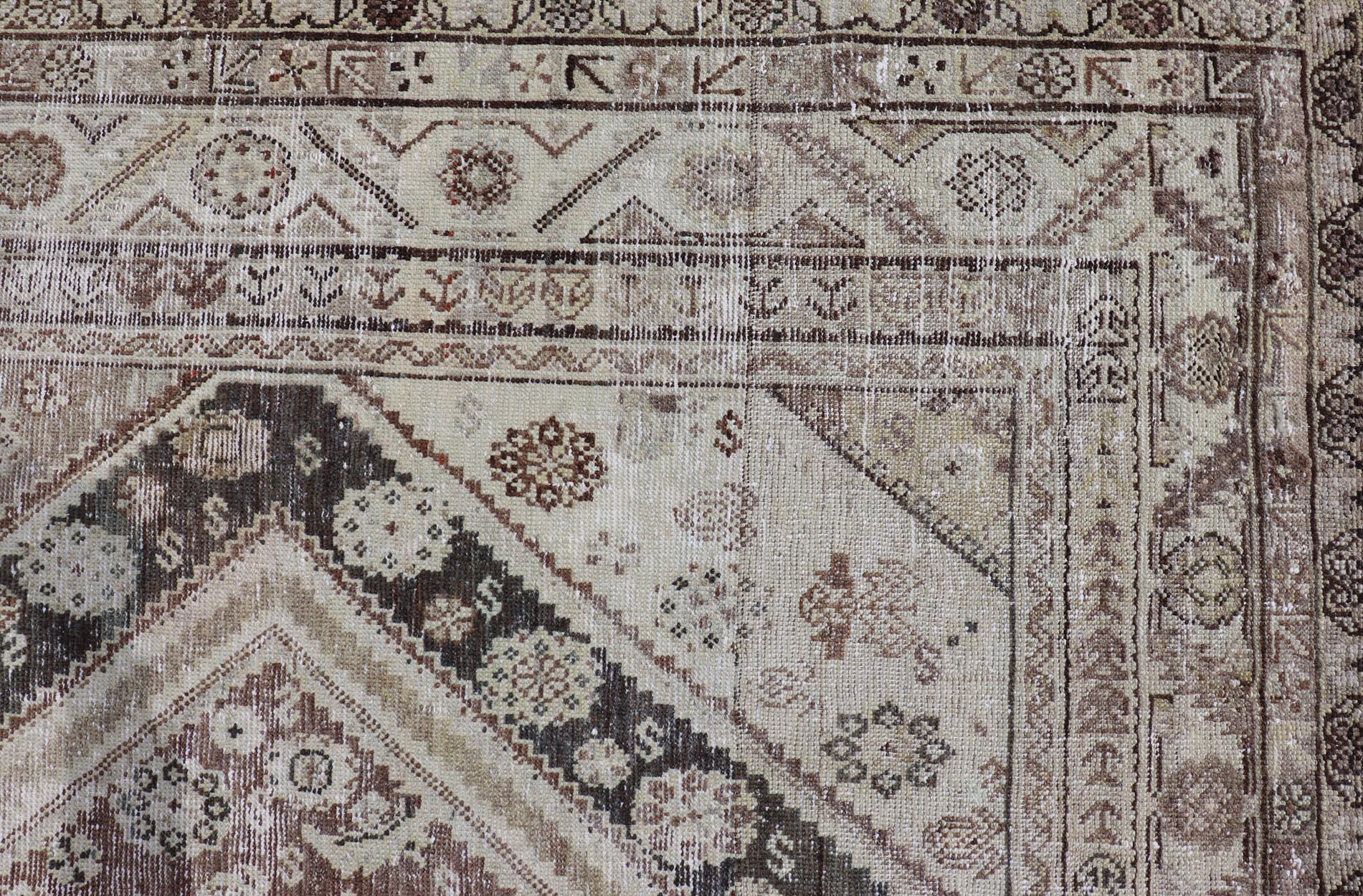 Cet ancien tapis persan Mahal Gallery a été noué à la main en laine et présente un motif de médaillon sub-géométrique multicolore. Une bordure complémentaire à plusieurs niveaux englobe la totalité de la pièce, ce qui lui permet de s'adapter