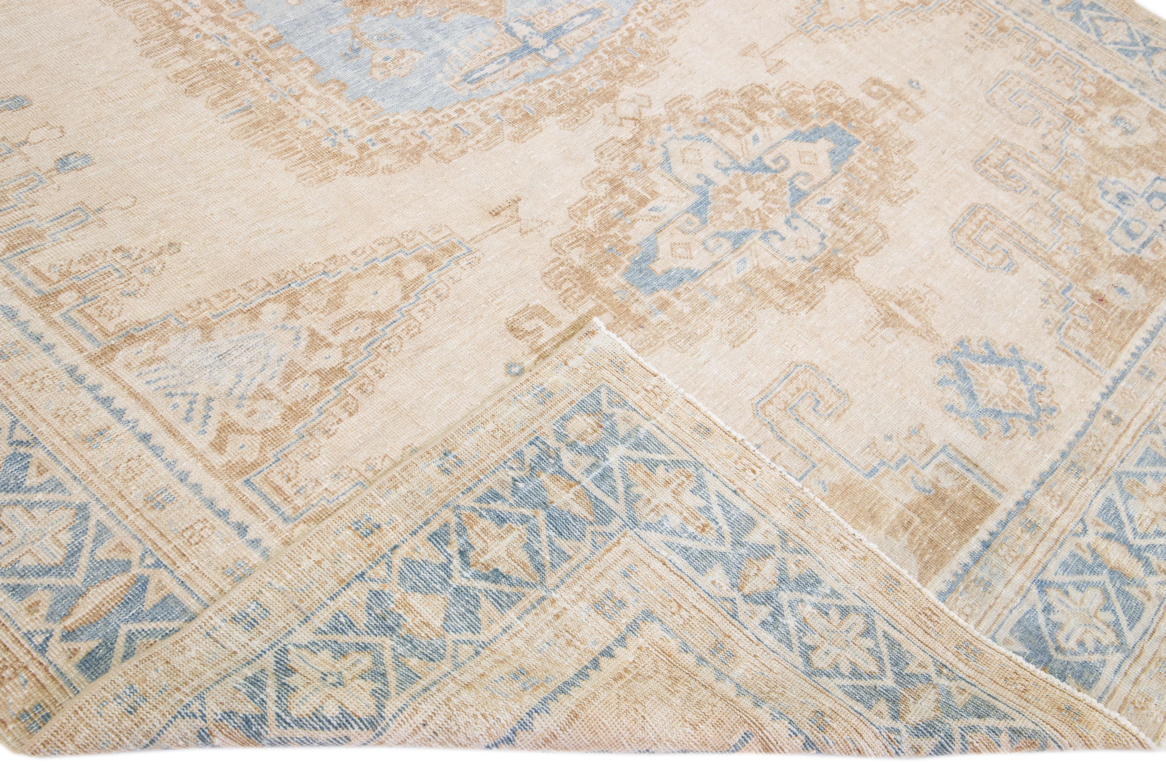 Beautiful Antique Mahal hand-knotted wool rug with a beige field. This Persian rug has blue accent color in an all-over geometric medallion design.

This rug measures 9'1