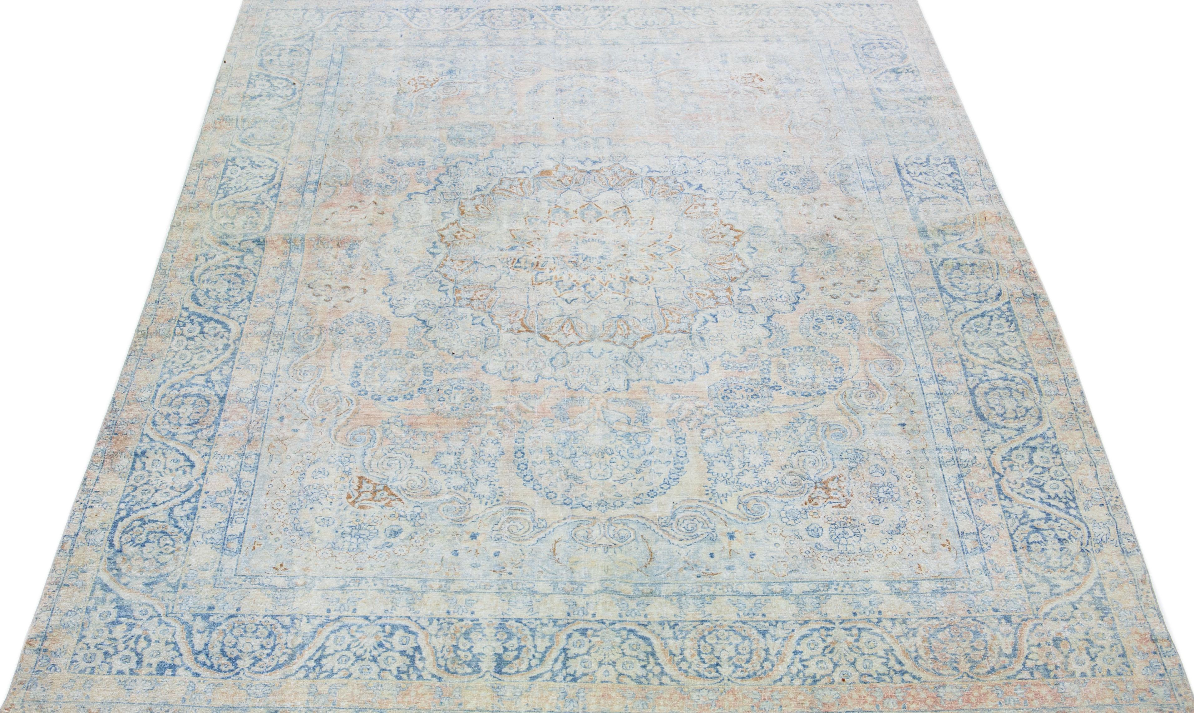 A beautiful Antique Mahal hand-knotted wool rug with a peach field. This Persian rug has blue and brown accents in an all-over rosette design.

This rug measures 10'2