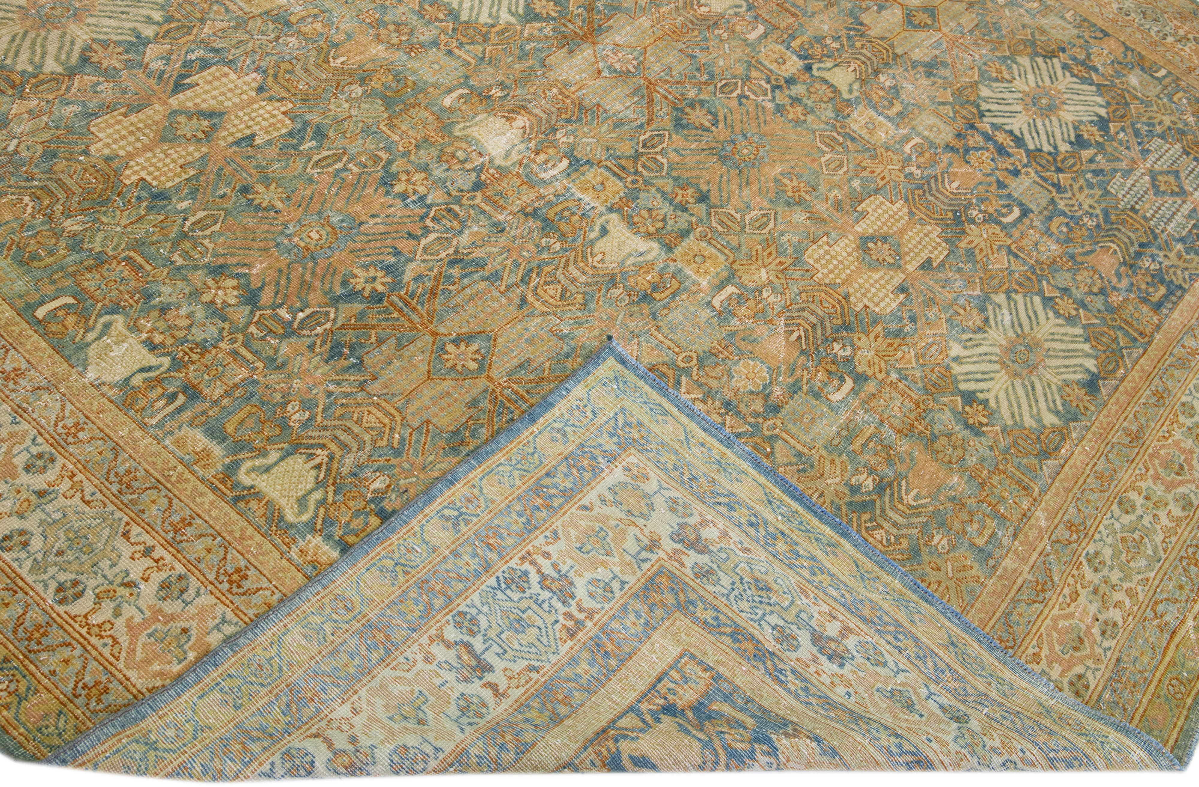 A beautiful Antique Mahal hand-knotted wool rug with a blue & rust-orange color field. This Persian rug has beige accents in an all-over floral design.

This rug measures 9'10