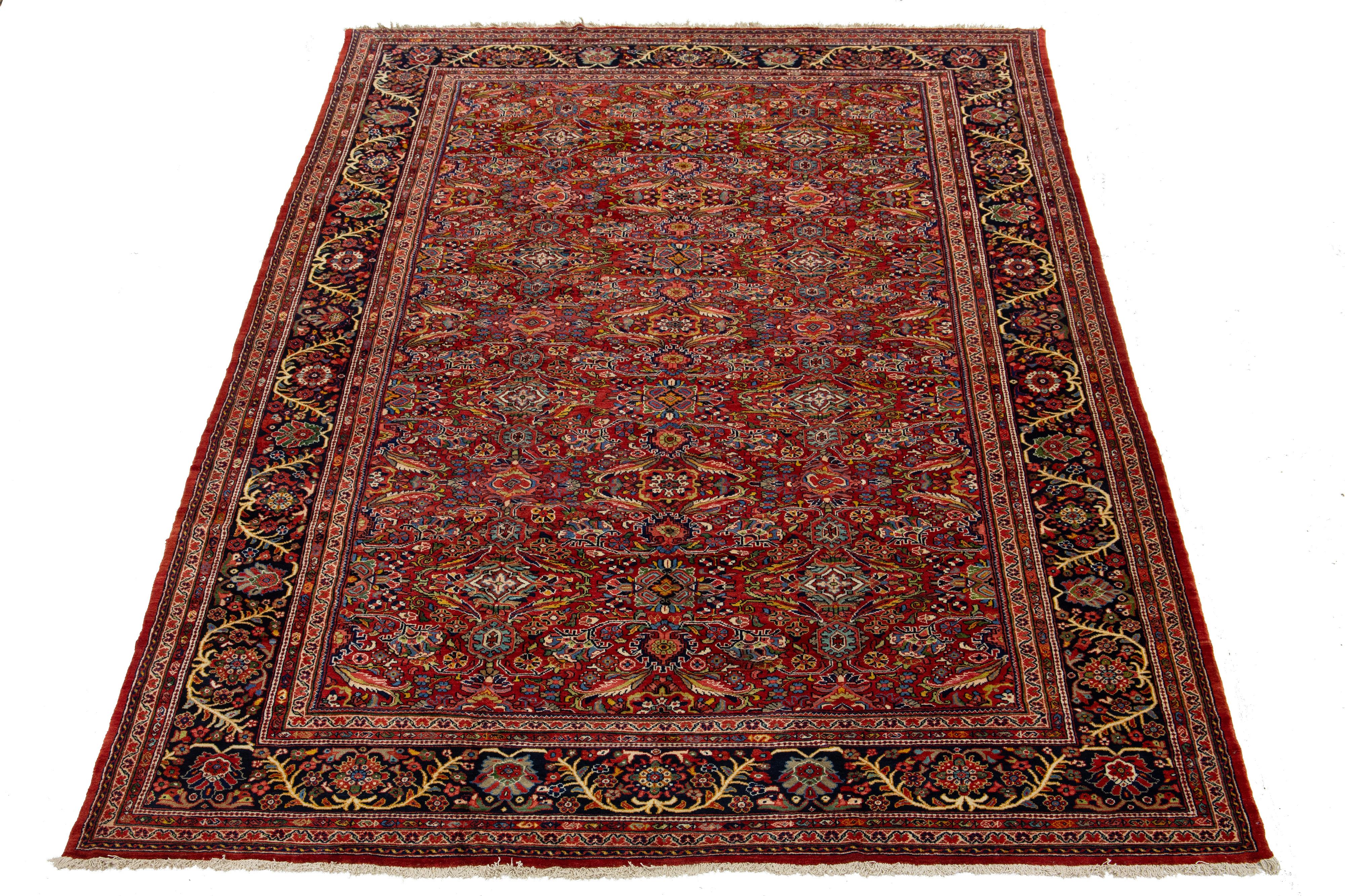 Transformez votre espace avec l'élégance intemporelle d'un tapis surdimensionné antique Mahal en laine nouée à la main, présentant un motif all-over saisissant sur un riche fond rouge.

Ce tapis mesure 11'1