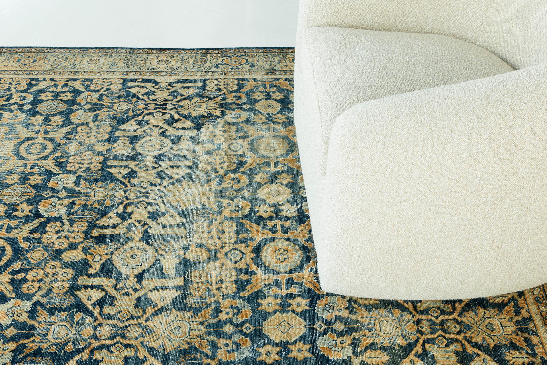 Deep indigo Abrash ground with all-over motif of interlocking geometricized palmettes and florals in apricot, blue and cream tones. The field pattern is organized in rows and columns. The border features palmettes and vine elements.

Rug number: