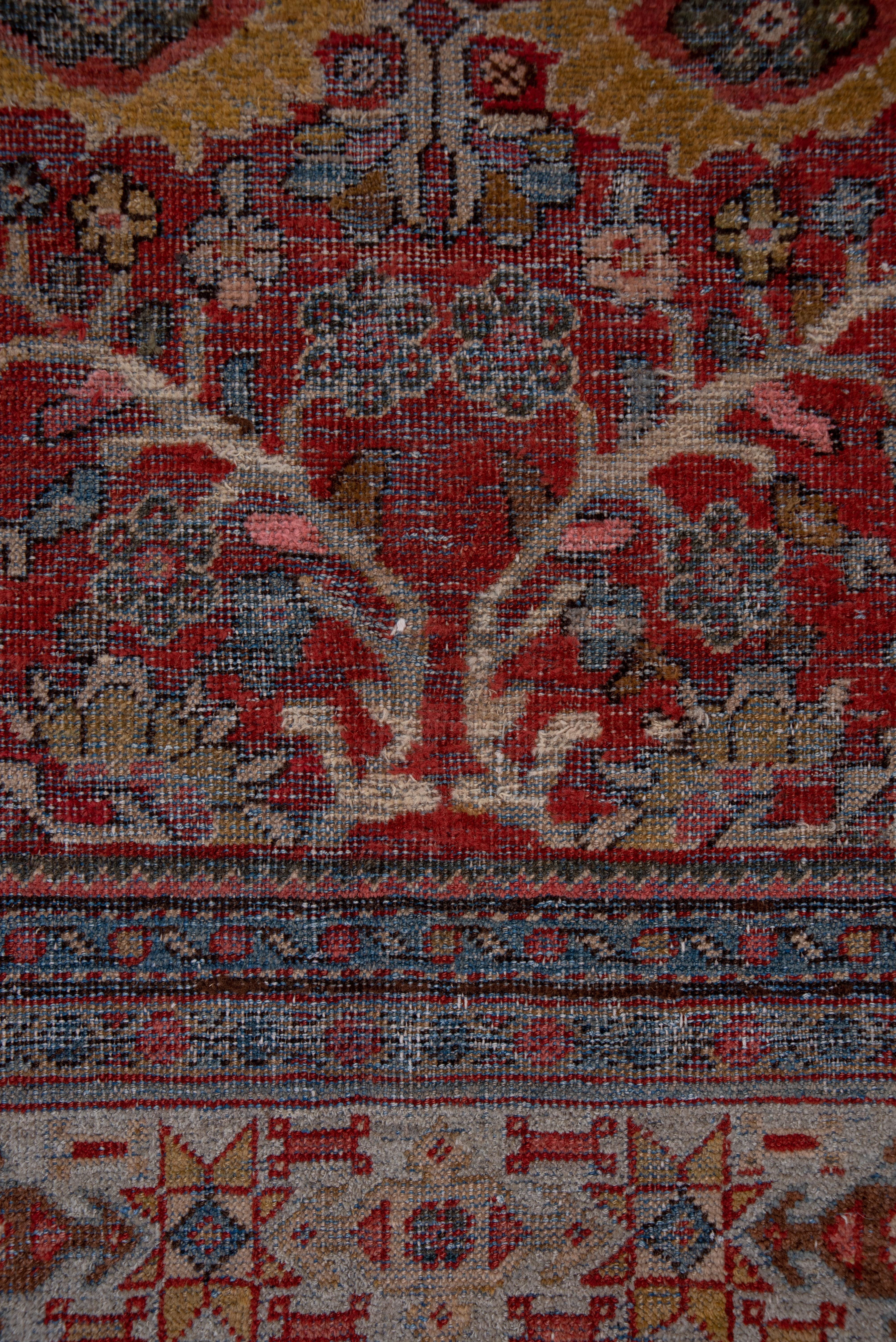 This coarsely woven, boldly patterned west Persian rustic carpet displays an octagonal red field with a rosette, palmette and thick tendril segment pattern within powder blue gray corners and a tonally matching border of stars and arrow headed