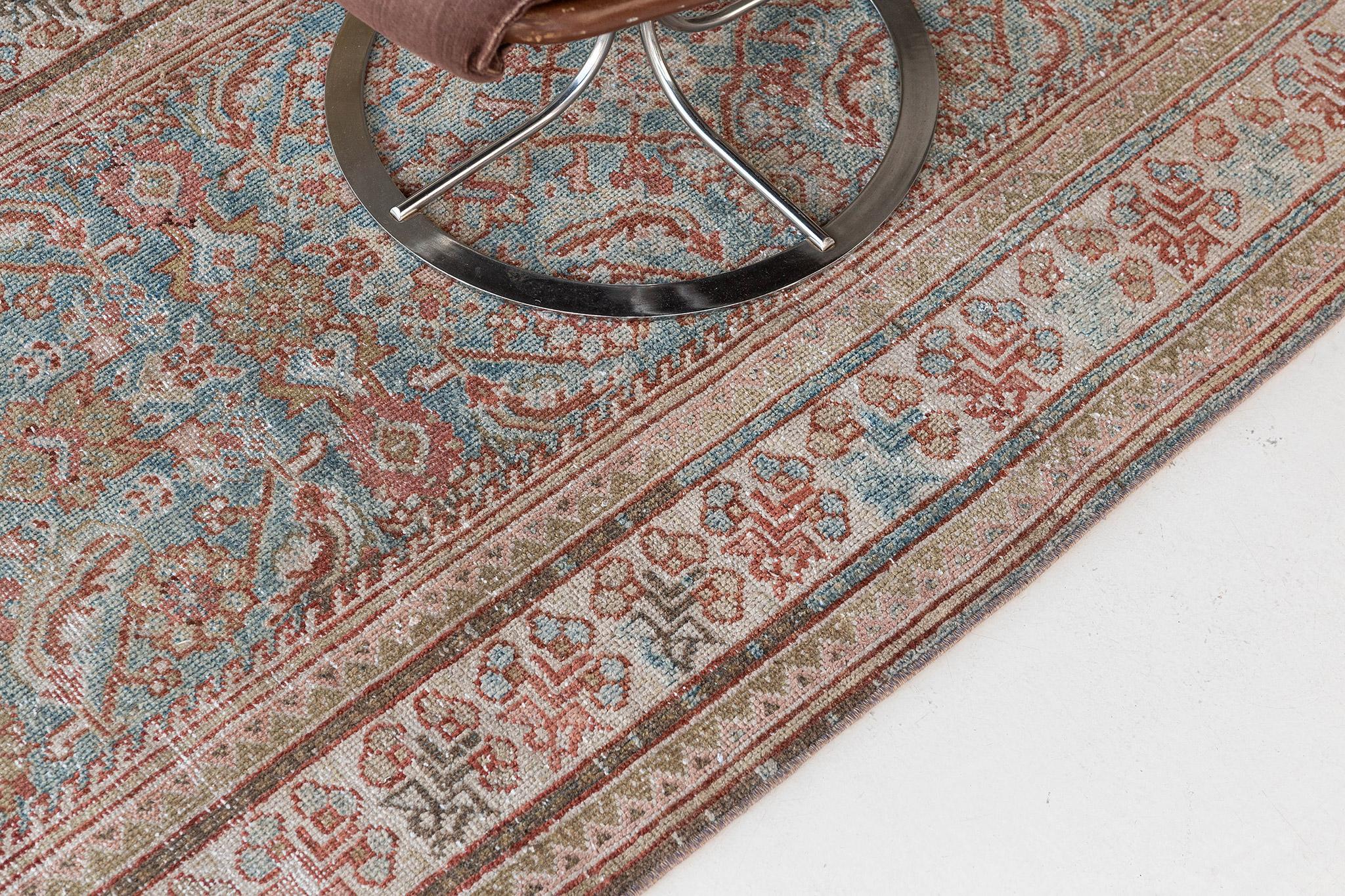 A sophisticated Antique Persian Mahal Runner that features timeless elegance and nostalgic charm. This enchanting rug is enclosed with a botanical border flanked with inner and outer guard bands. The abrashed sapphire field is covered graciously