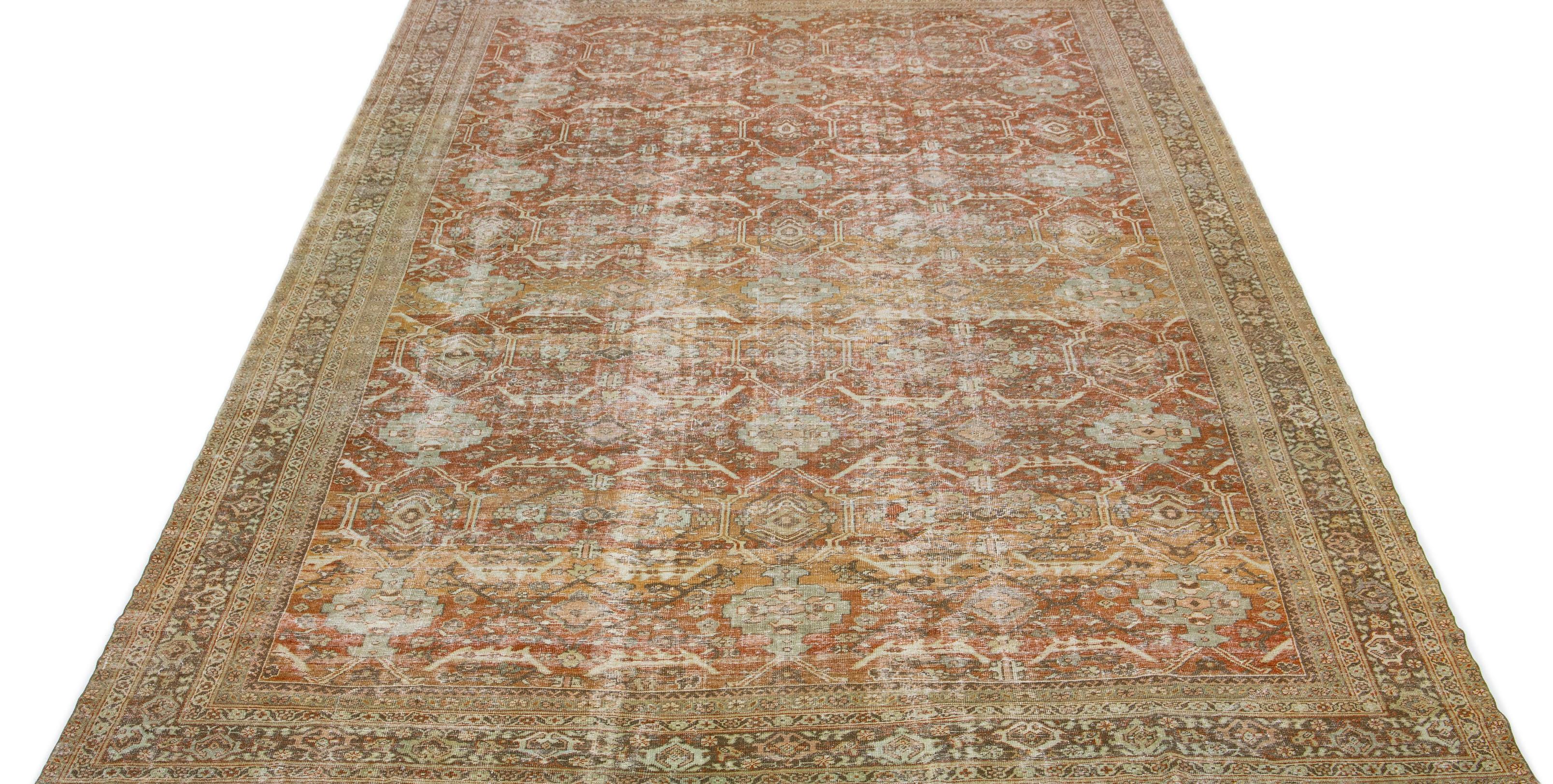 The 1920s vintage wool rug with hand-knotted craftsmanship features an All-over floral motif. Its primary color scheme consists of orange/rust complimented with blue, peach, and gray hues for a traditional appeal.

This rug measures 11' x 17'7
