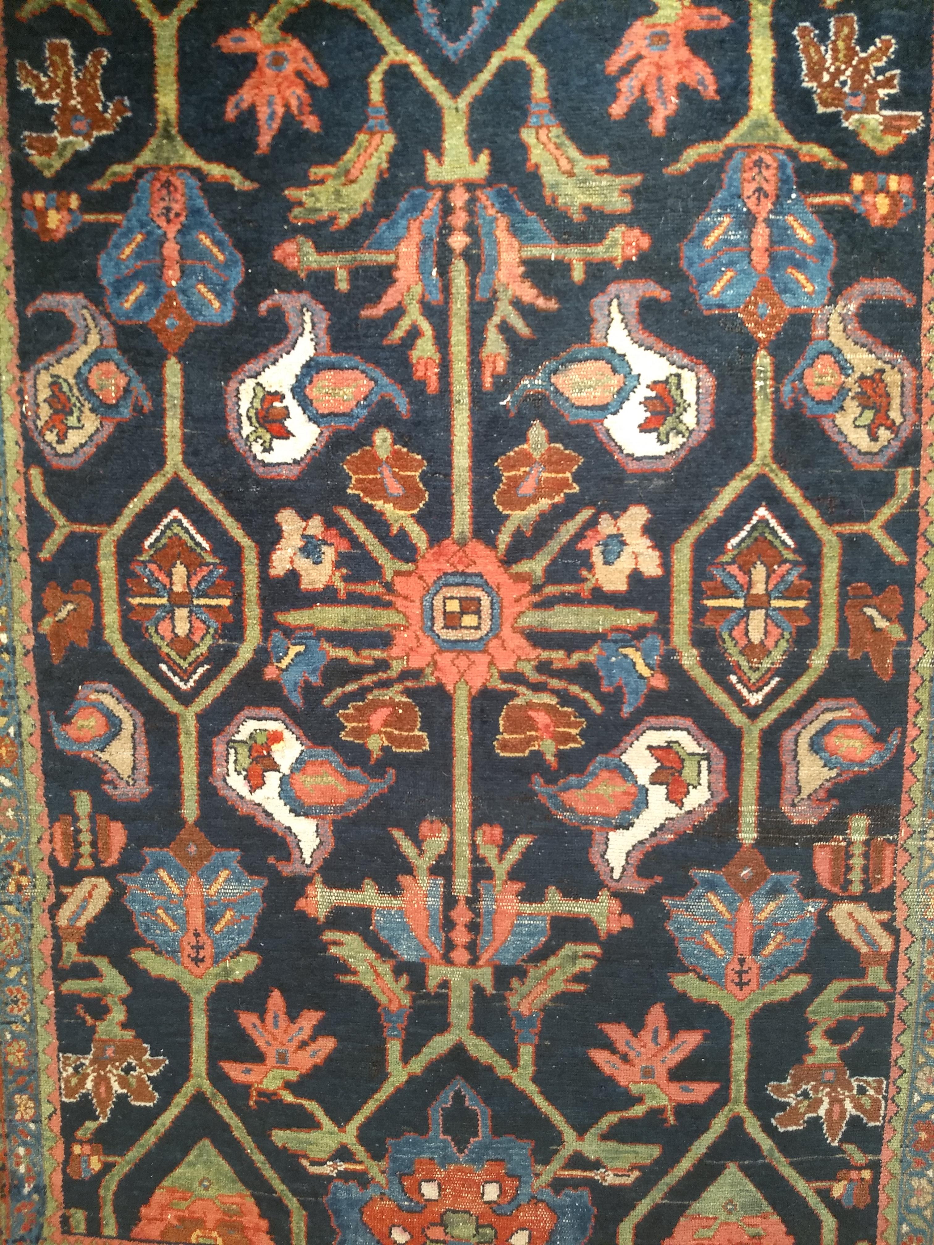 A vintage Persian Mahal Sultanabad area rug in an all over geometric pattern in navy blue, dark red, green, and French blue.   The Mahal Sultanabad area  rug has a midnight blue field color with large geometric and floral designs in French blue,