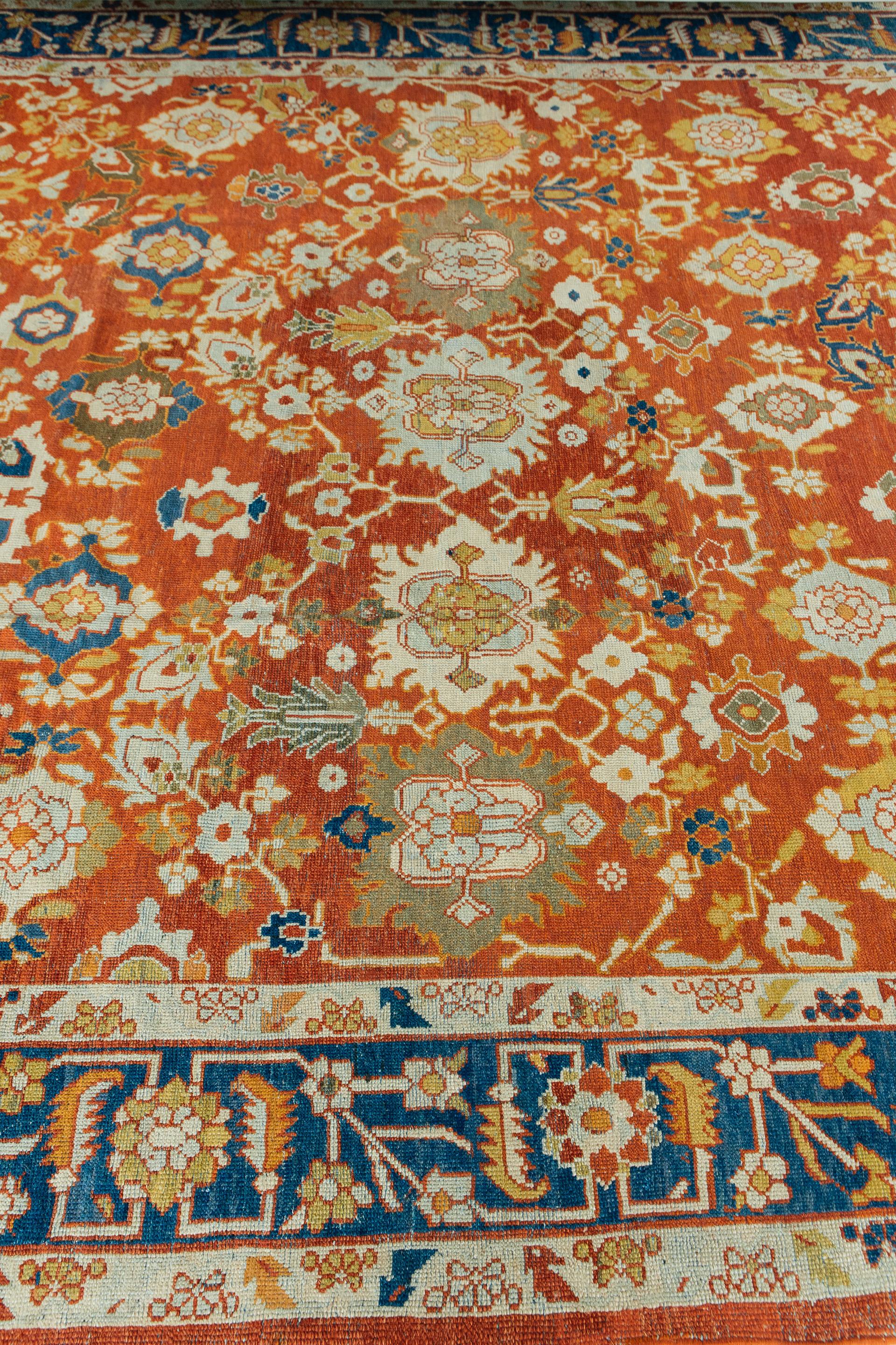This Antique Mahal features a bold, red-brick field and blue border with gold, pale blue, ivory and olive accents. Rows of large-scale palmettes and floral motifs establish an active all-over design. This is a stately design produced for the