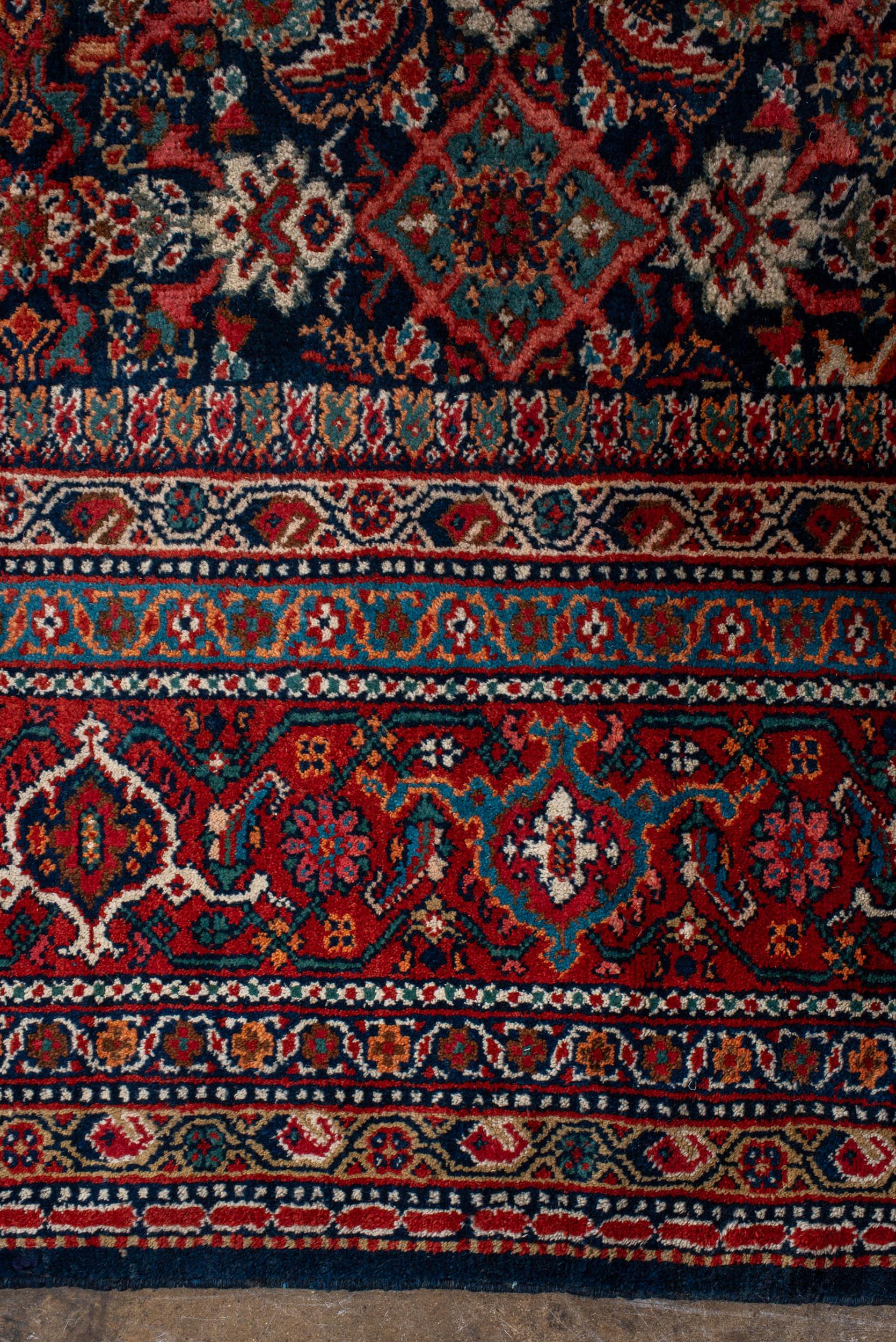 The Antique Persian Mahal rug is a traditional handwoven luxury rug with a multi-color design. Its size measures approximately 12 feet in width and 13 feet 10 inches in length. The term 
