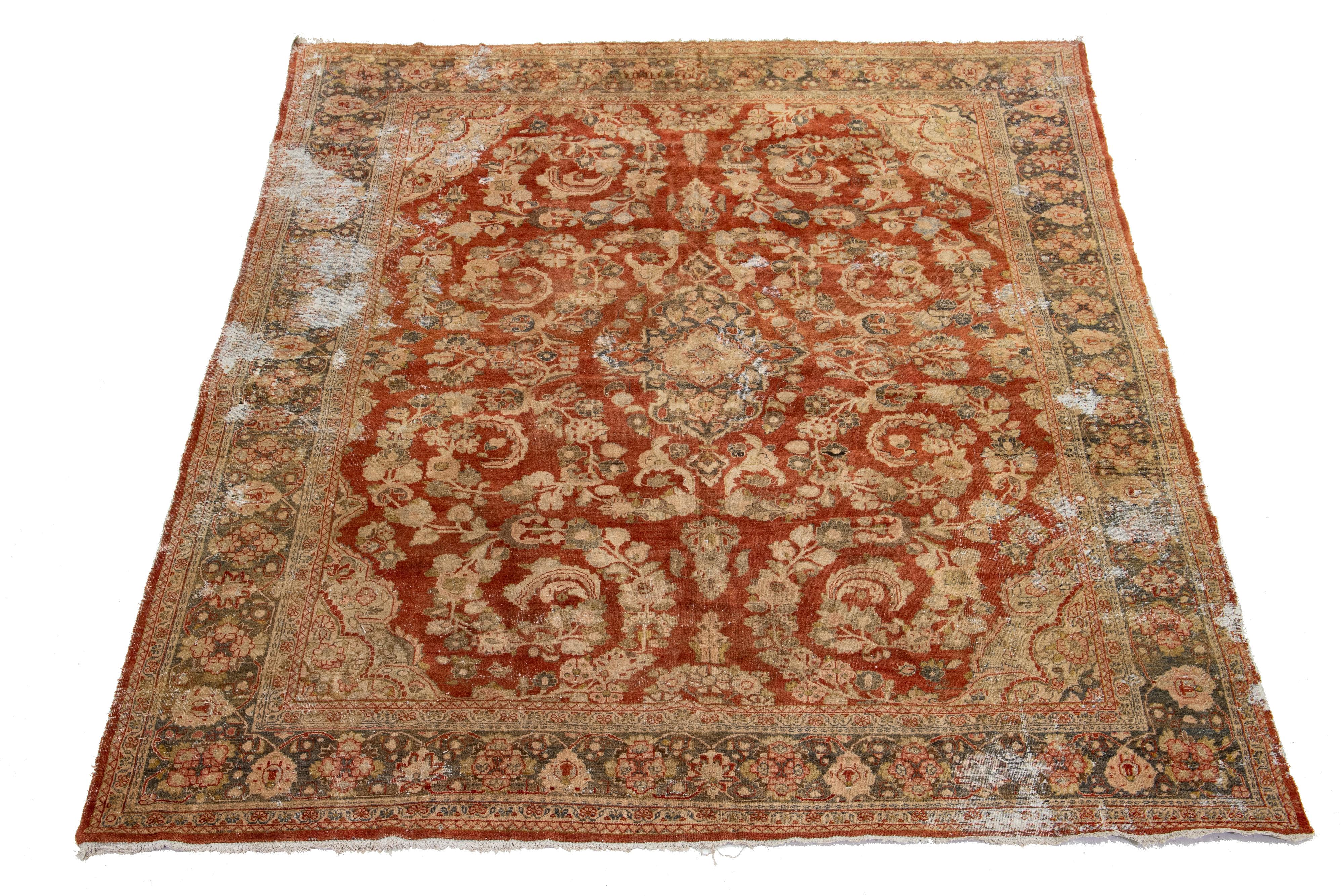 A hand-knotted wool antique Mahal distressed rug features an all-over design with gray, goldenrod, and beige accents on a red-rust color field.

This rug measures 10'10