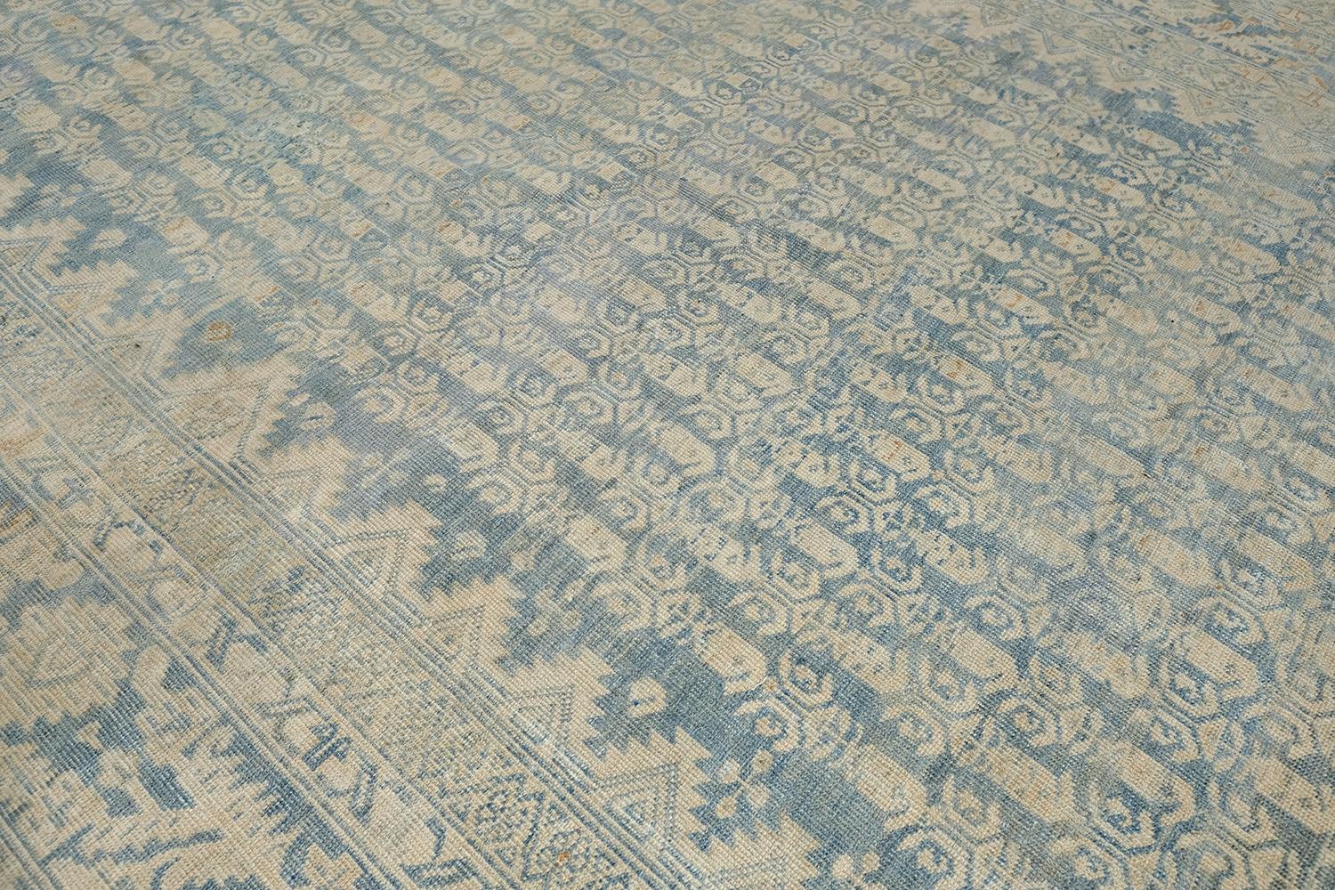 Dieser elegante und zeitlose persische Malayer-Teppich zeichnet sich durch ein raffiniertes Muster aus und ist mit gedämpften Spiegelmustern über das gesamte Design versehen. Eine sandfarbene Farbpalette aus feld- und tealfarbenen Elementen wird