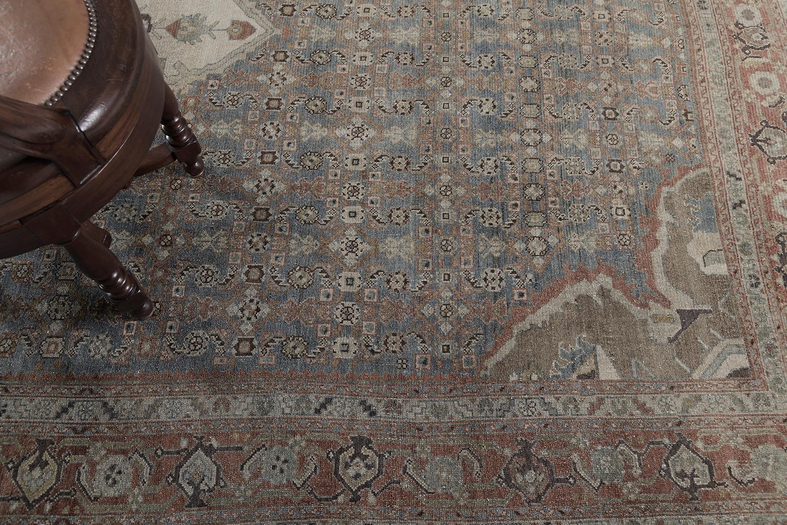 A mesmerizing Antique Persian Malayer rug that is stunningly woven in aan allover botanical motifs in the soothing muted tones of aegean blue and cinnamon. This breathtaking rug is adorned with various botanicals that formed together creating a