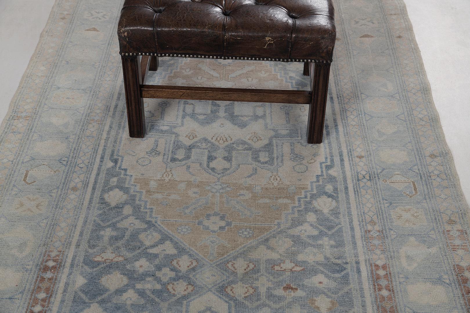 A fascinating Antique Persian Malayer rug that features the warm tones of aegean blue, gold, ivory and sand in the most sought after earthy colour palette. Various central medallions overlaid in a majestic botanical patterns create an alluring