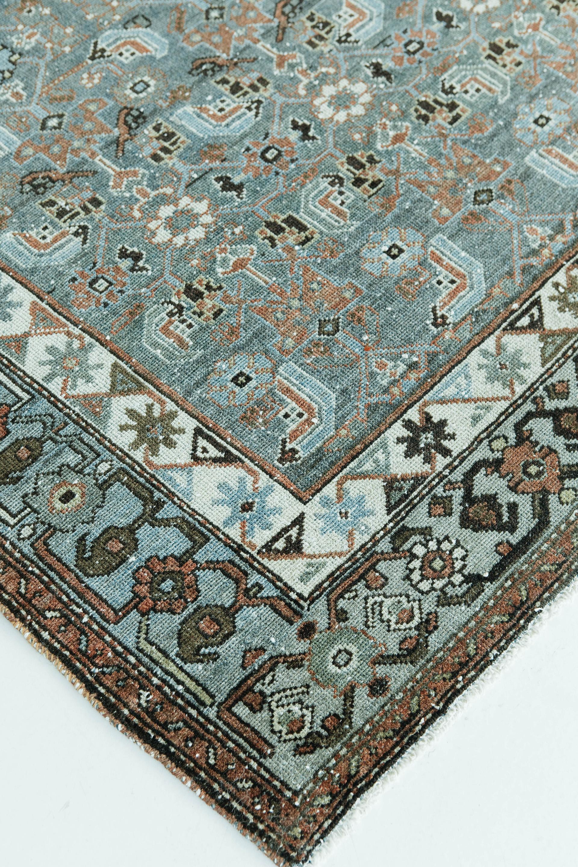 Blue abrash ground with all-over lattice design of geometricized floral elements in red, brown and ivory tones. A similarly stylized border of rosettes and vines frames the piece. This is a stunning vintage Malayer from northwestern Iran.

Rug