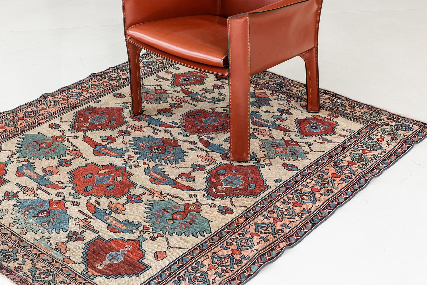This majestic Malayer rug comes from a handmade finest wool that features ruby and cerulean blue motifs and medallions in a pale caramel field. A sophisticated masterpiece surrounded by a symmetrical leaf scroll, florid designs, and motifs, that