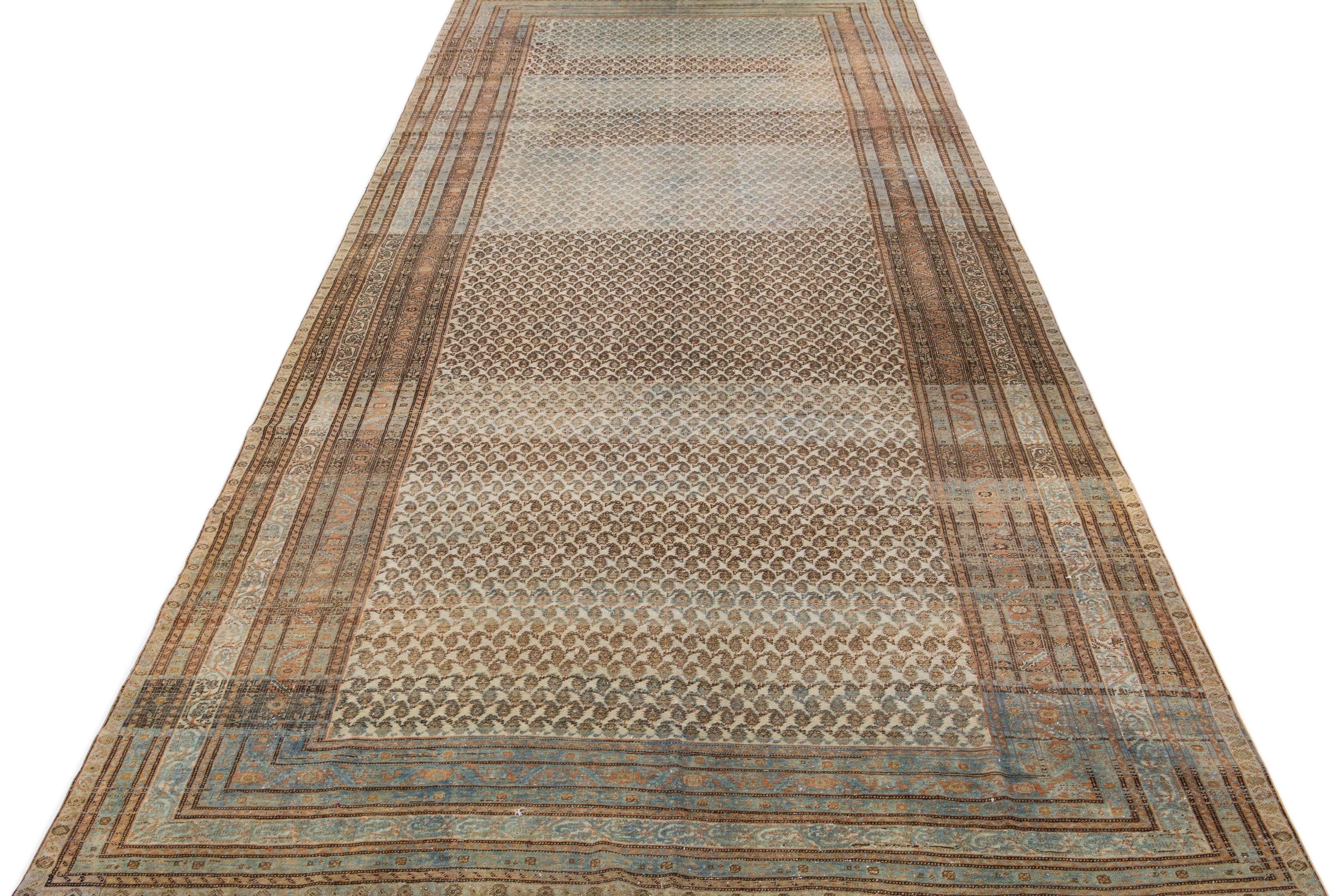 Beautiful antique Malayer hand-knotted wool rug with a beige color field. This Persian rug has brown, blue, and rust accents in a gorgeous traditional floral design.

This rug measures: 7' 4