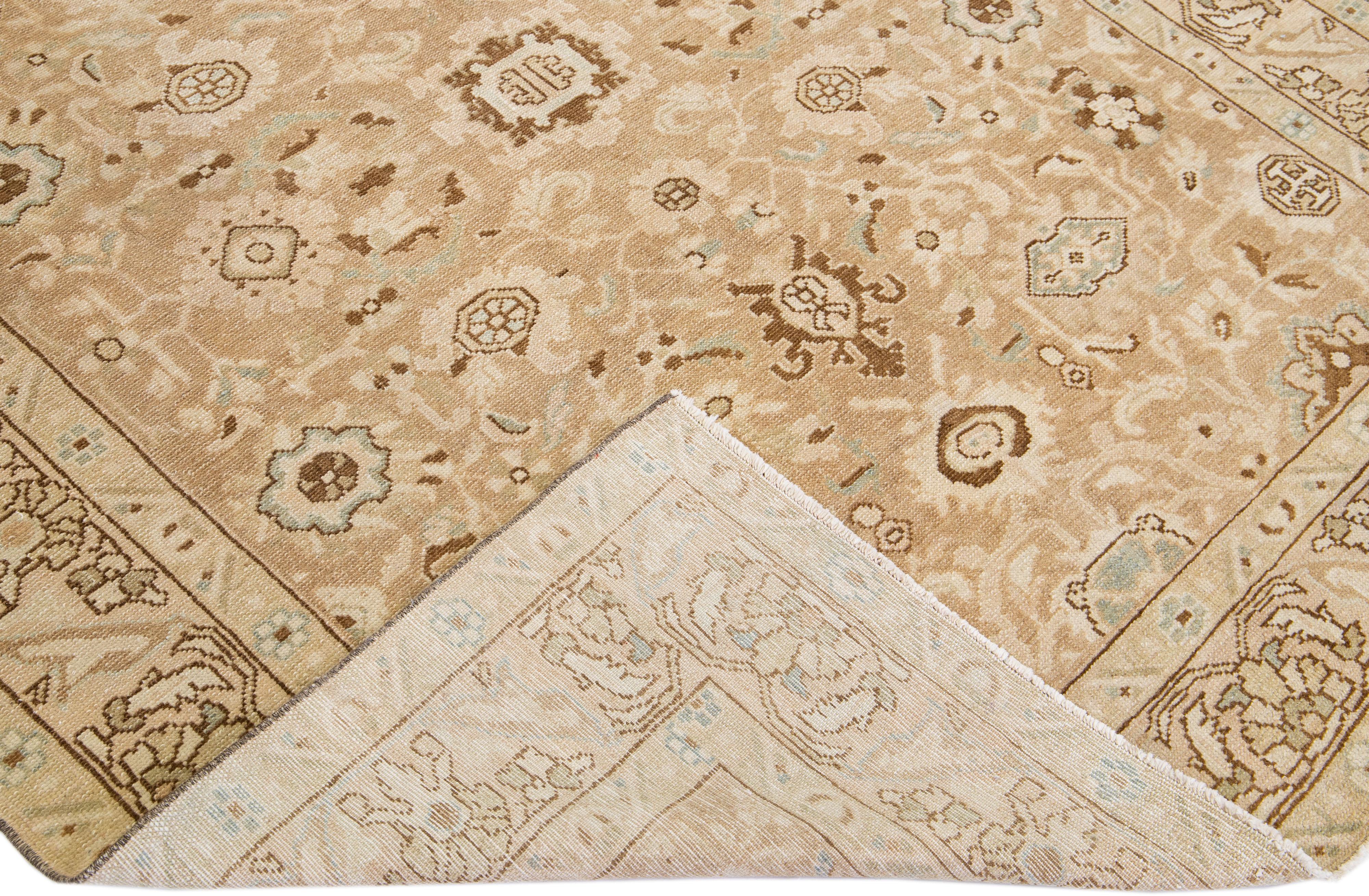 A beautiful Antique Malayer hand-knotted wool rug with a beige color field. This rug has blue and brown accents in an all-over floral pattern design.

This rug measures 5'6