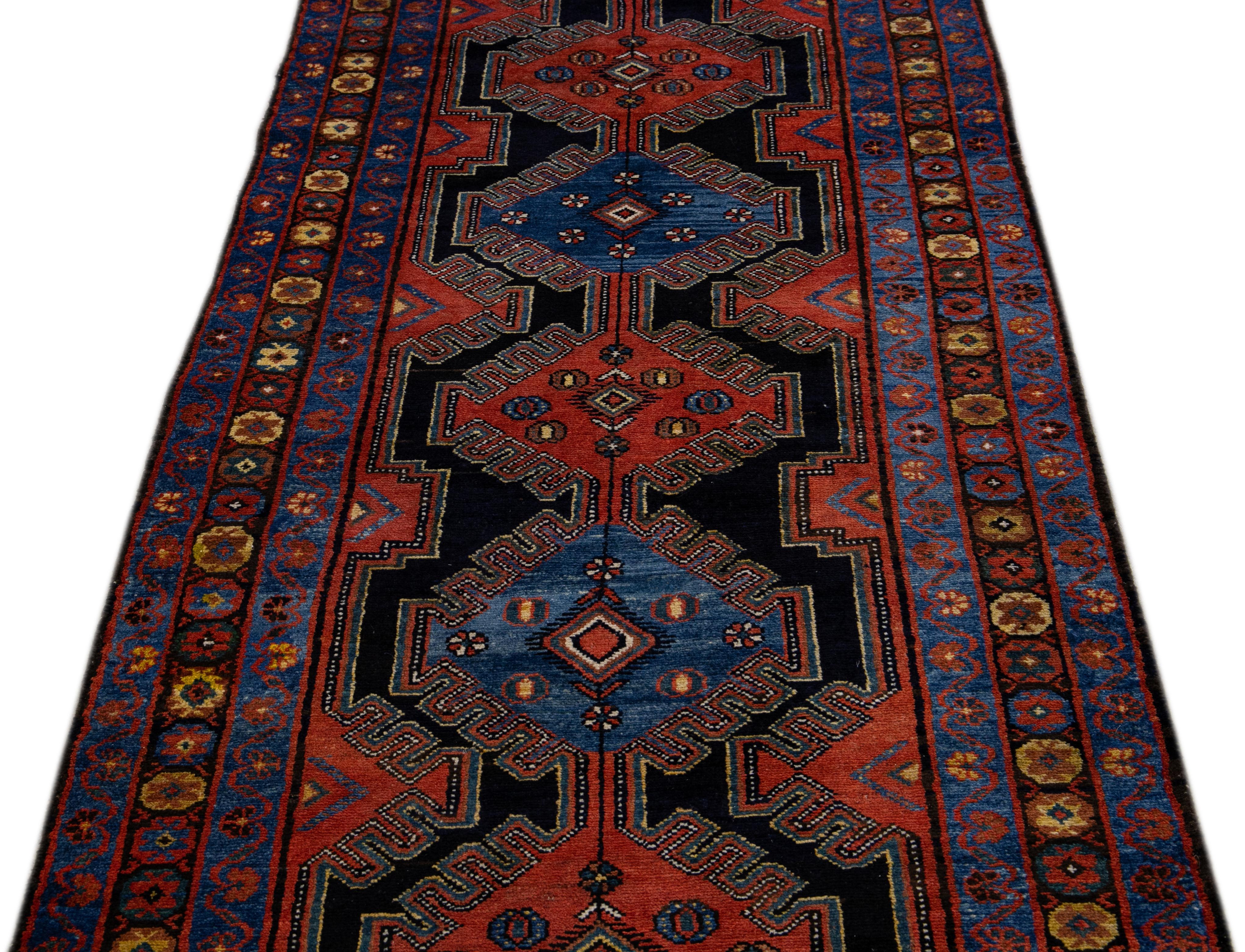 Beautiful antique Malayer hand-knotted wool runner with the dark ink-blue field. This Persian piece features a wide double border in alternating blue and rust with some yellow accents in an all-over tribal design. 

This runner measures 3'3