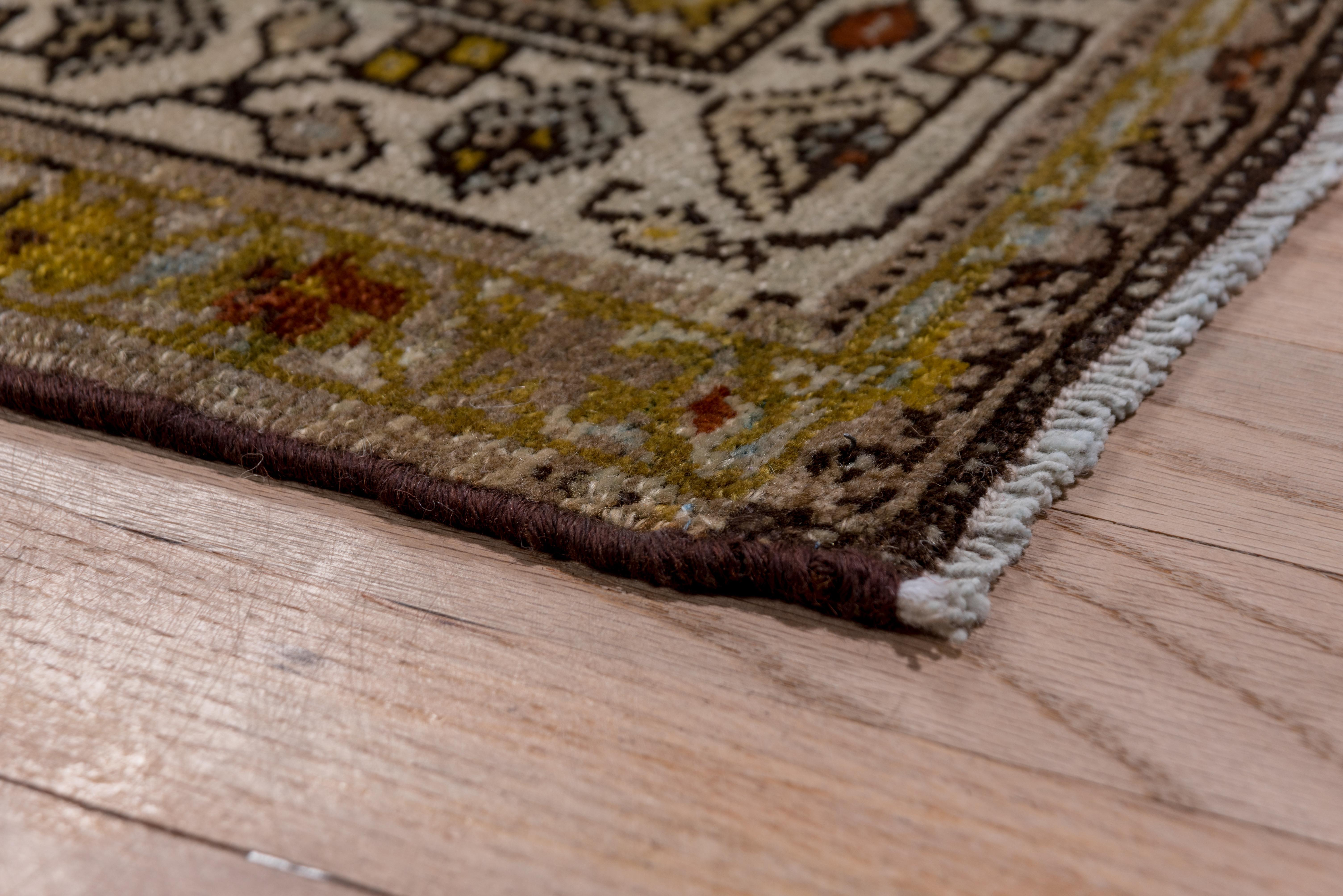 The near black field shows a three column Herati design highlighted with green, rust and ecru. Cream, gray and olive borders with blossoms, squares, botehs and a trapezoidal meander. On cotton, medium weave, west Persian Malayer runner. Good