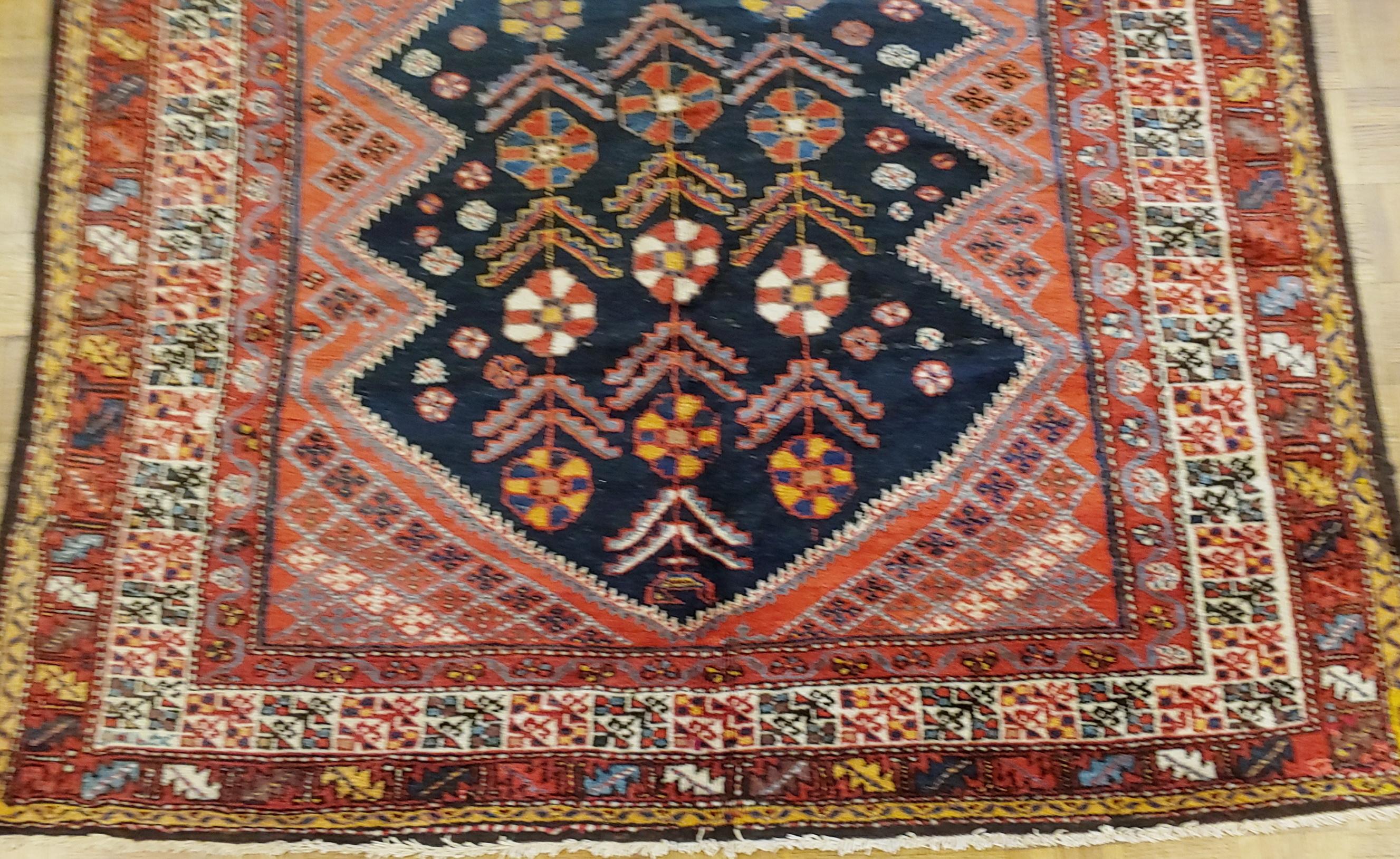 This antique Persian Malayer has a navy field with a floral design with a secondary outer field covered with small geometric diamond design. The border is a series of narrow bands. The colors are reds, navy, rust, and yellow. These very fine Malayer