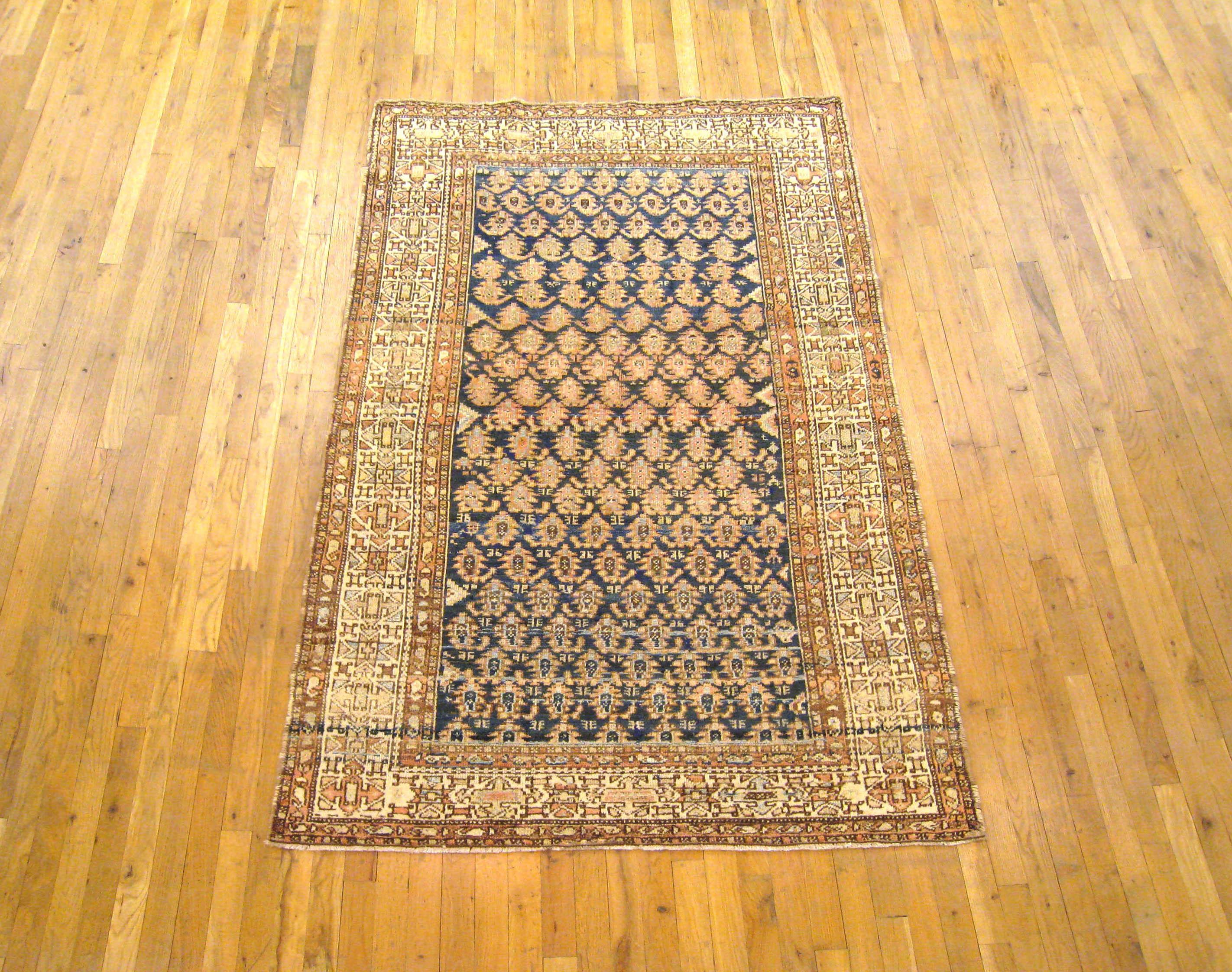 An antique Persian Malayer rug, size 6'8 x 4'3, circa 1910. This lovely rug has a unique paisley design in its blue primary field, with a number of variations on the paisley motif appearing successively from one end to the other. The field is
