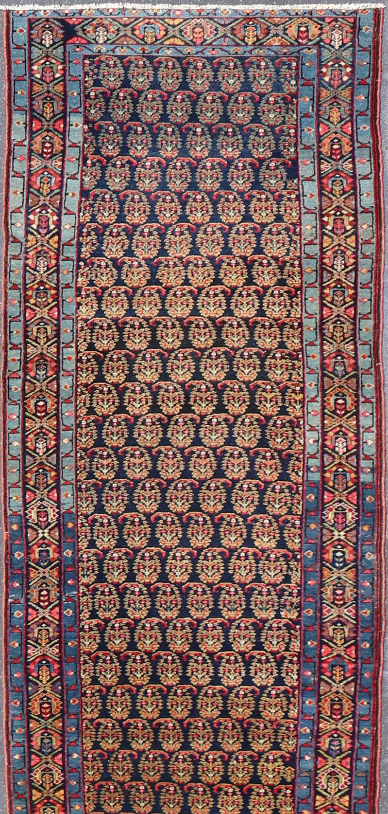 Measures 3'7 x 18'7

This antique Persian Malayer features a denim blue guard for the small banded border, decorated with modest motifs in varying shades of blue, green, yellow, and pink. The dark field homes a classic paisley field design