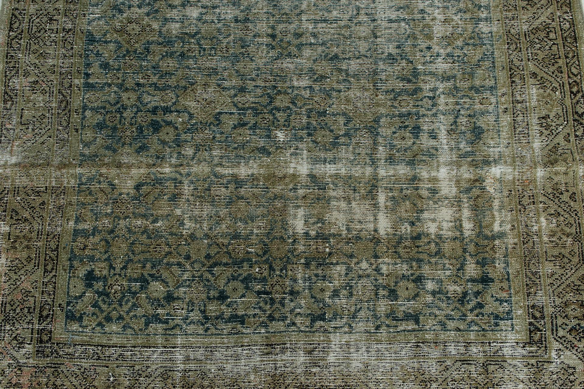 Mottled with wear, this antique Malayer has a rugged appeal with deep teal abrash field and rich, olivey taupe throughout. An all-over mina khani pattern of florets and diamond lattice emerges through the foundation. Borders of meander motifs frame