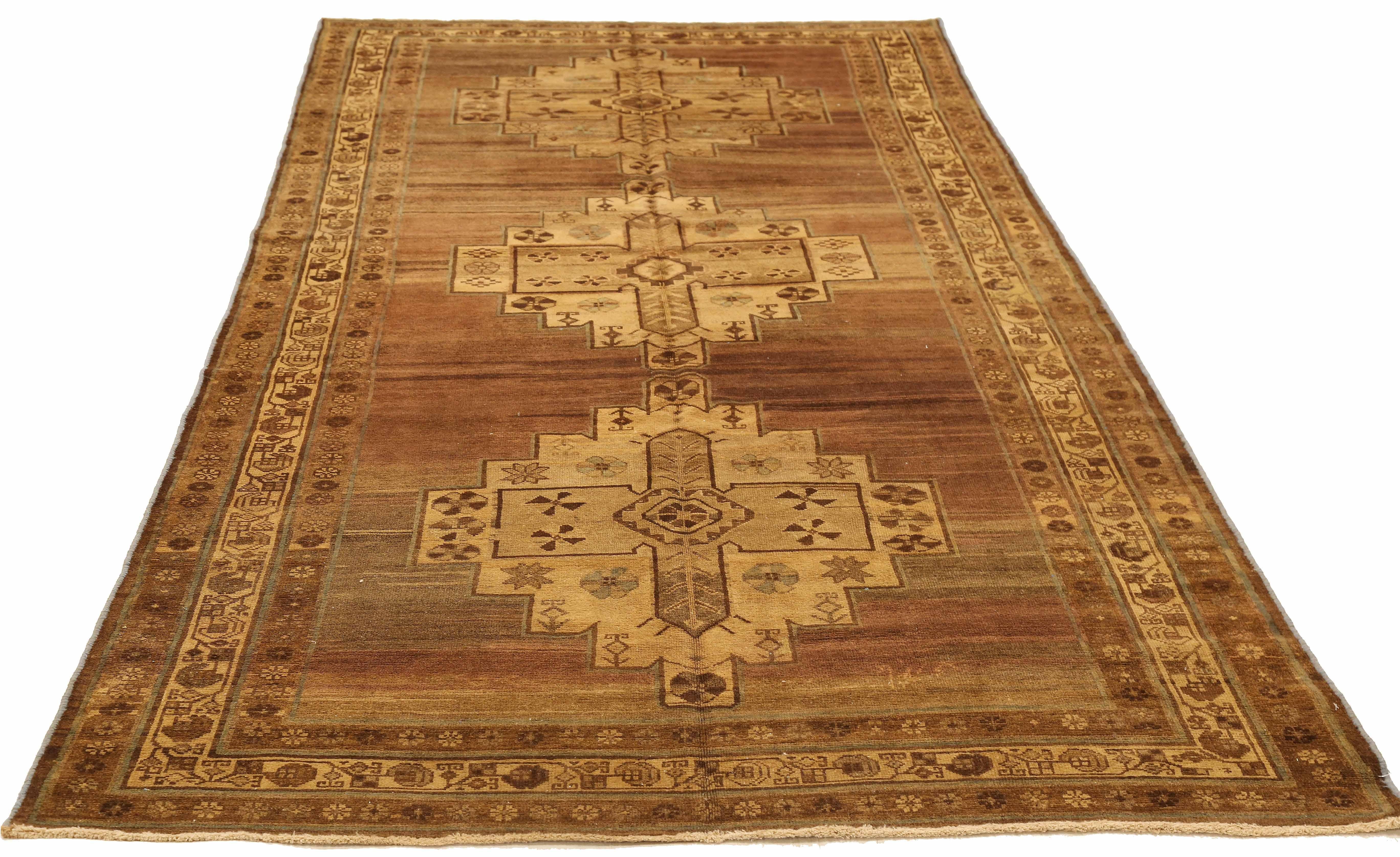 Antique Persian runner rug handwoven from the finest sheep’s wool and colored with all-natural vegetable dyes that are safe for humans and pets. It’s a traditional Malayer design featuring three large cross-like flower medallion details over a brown