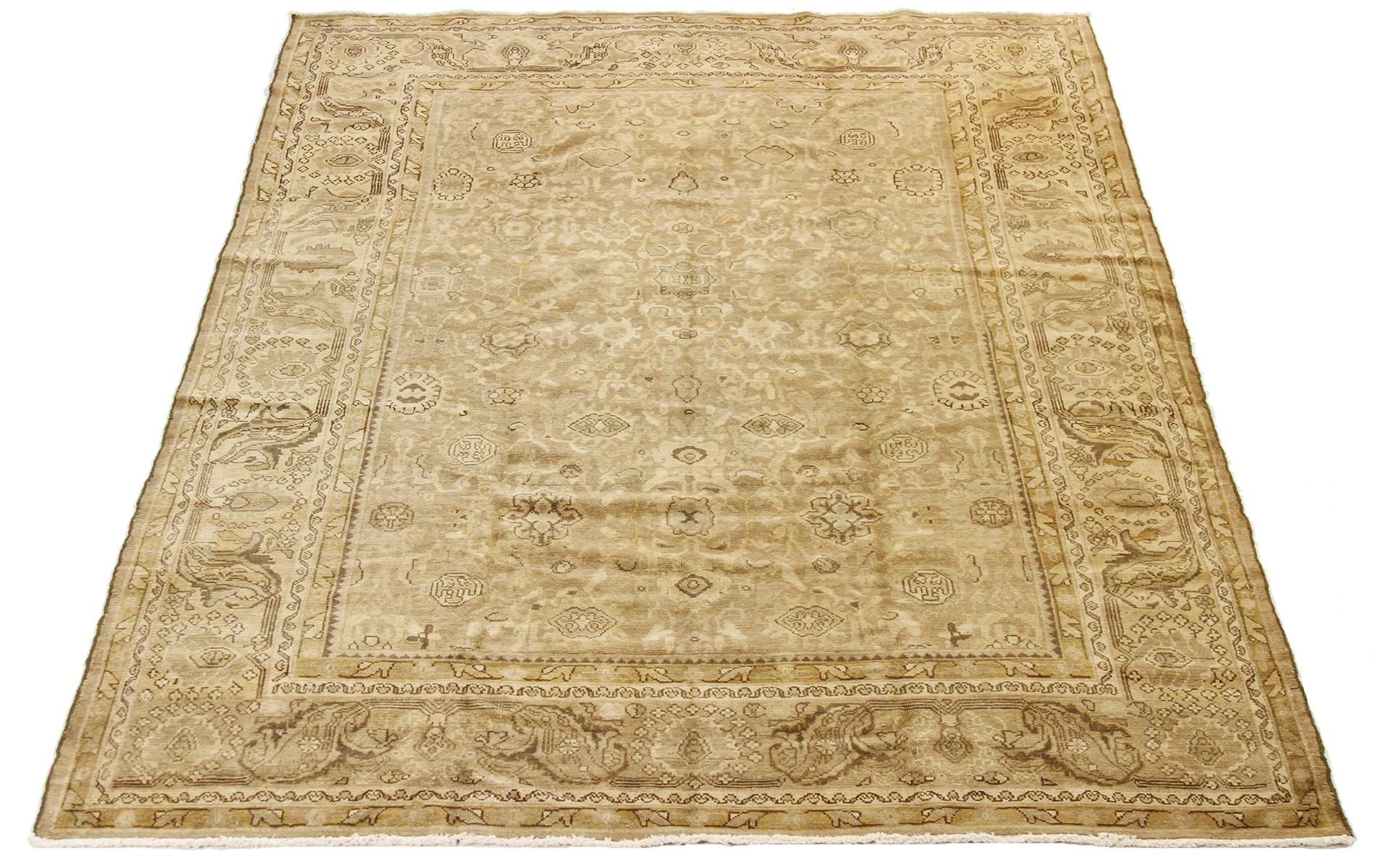 Antique Persian rug handwoven from the finest sheep’s wool and colored with all-natural vegetable dyes that are safe for humans and pets. It’s a traditional Malayer design featuring brown and beige floral details all over its ivory field. It’s a
