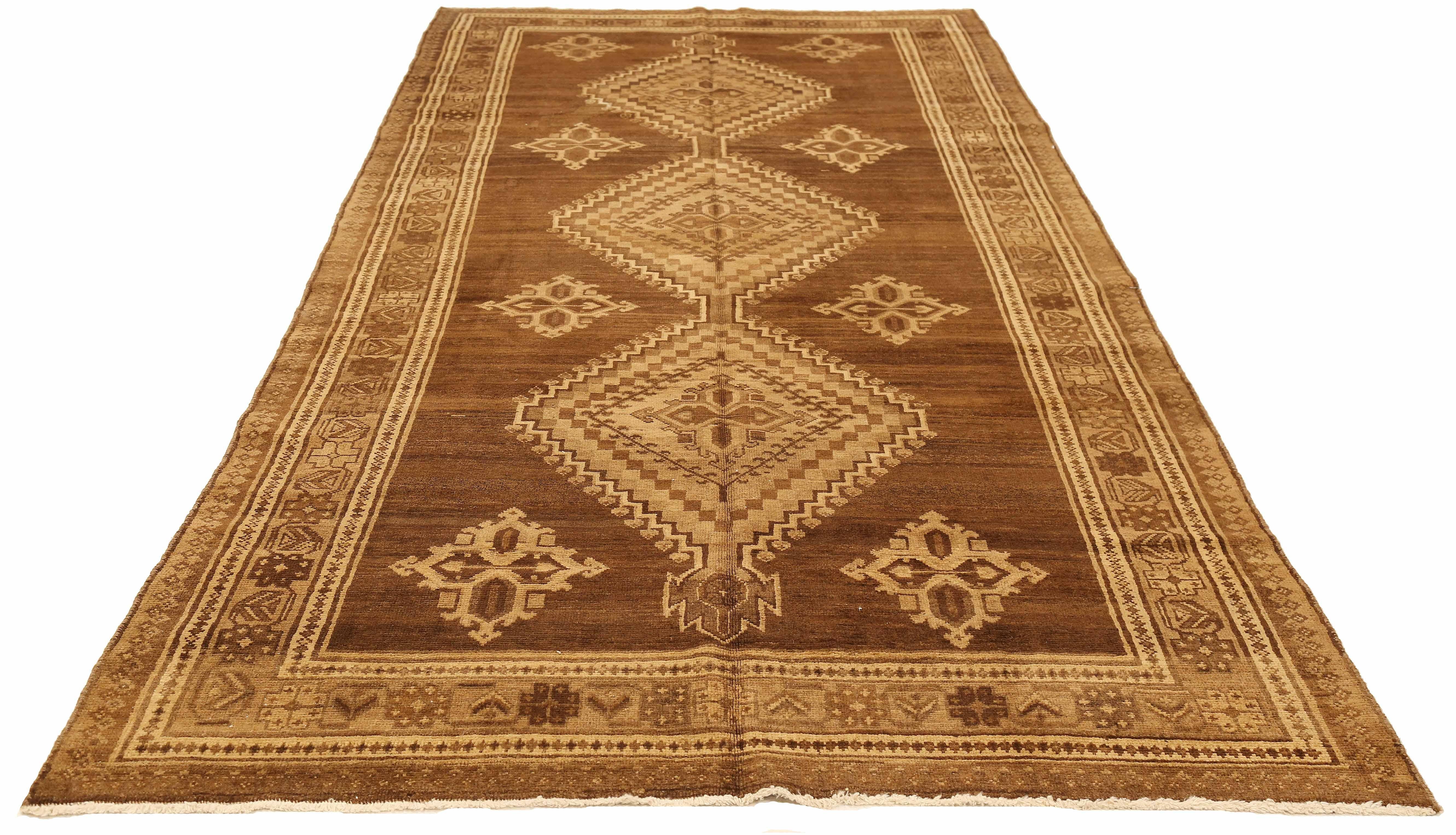 Antique Persian runner rug handwoven from the finest sheep’s wool and colored with all-natural vegetable dyes that are safe for humans and pets. It’s a traditional Malayer design featuring brown and beige medallion details over a brown field. It’s a