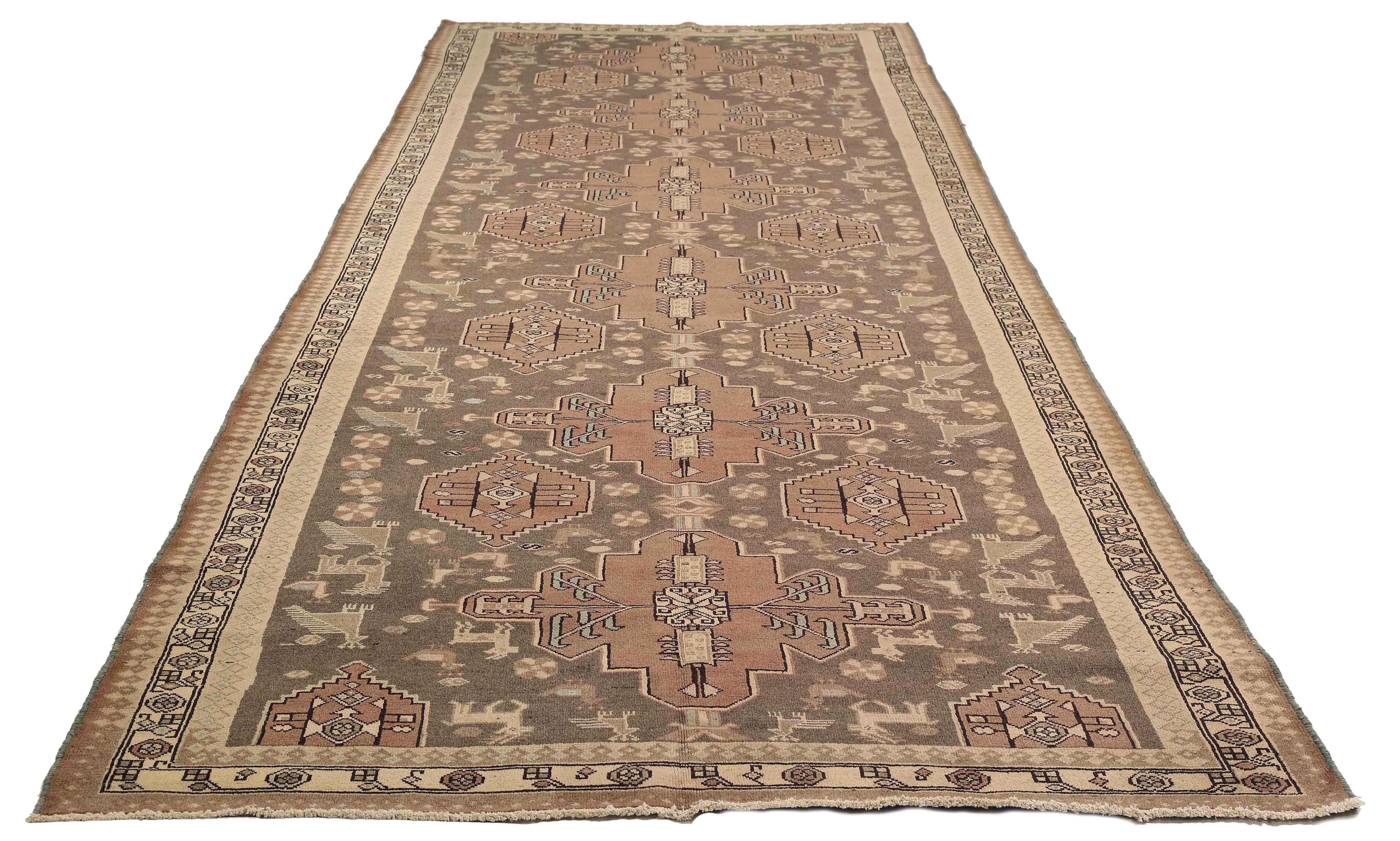 Antique Persian rug handwoven from the finest sheep’s wool. It’s colored with all-natural vegetable dyes that are safe for humans and pets. It’s a traditional Malayer design featuring brown and black tribal details on a beige field. It’s a lovely