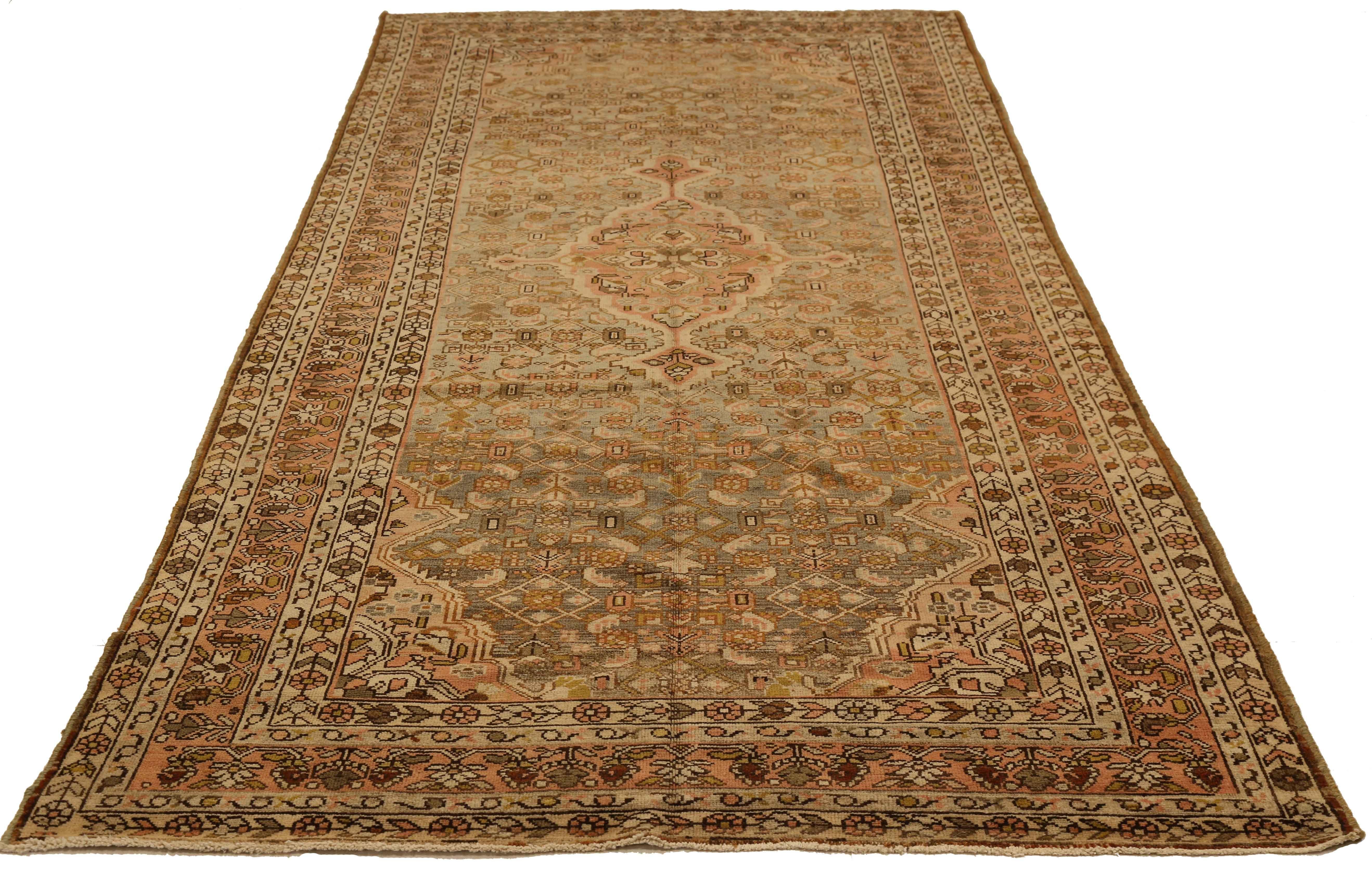 Antique Persian rug handwoven from the finest sheep’s wool. It's colored with all-natural vegetable dyes that are safe for humans and pets. It’s a traditional Malayer design featuring a mix of pink, and brown floral details over an ivory field. It’s