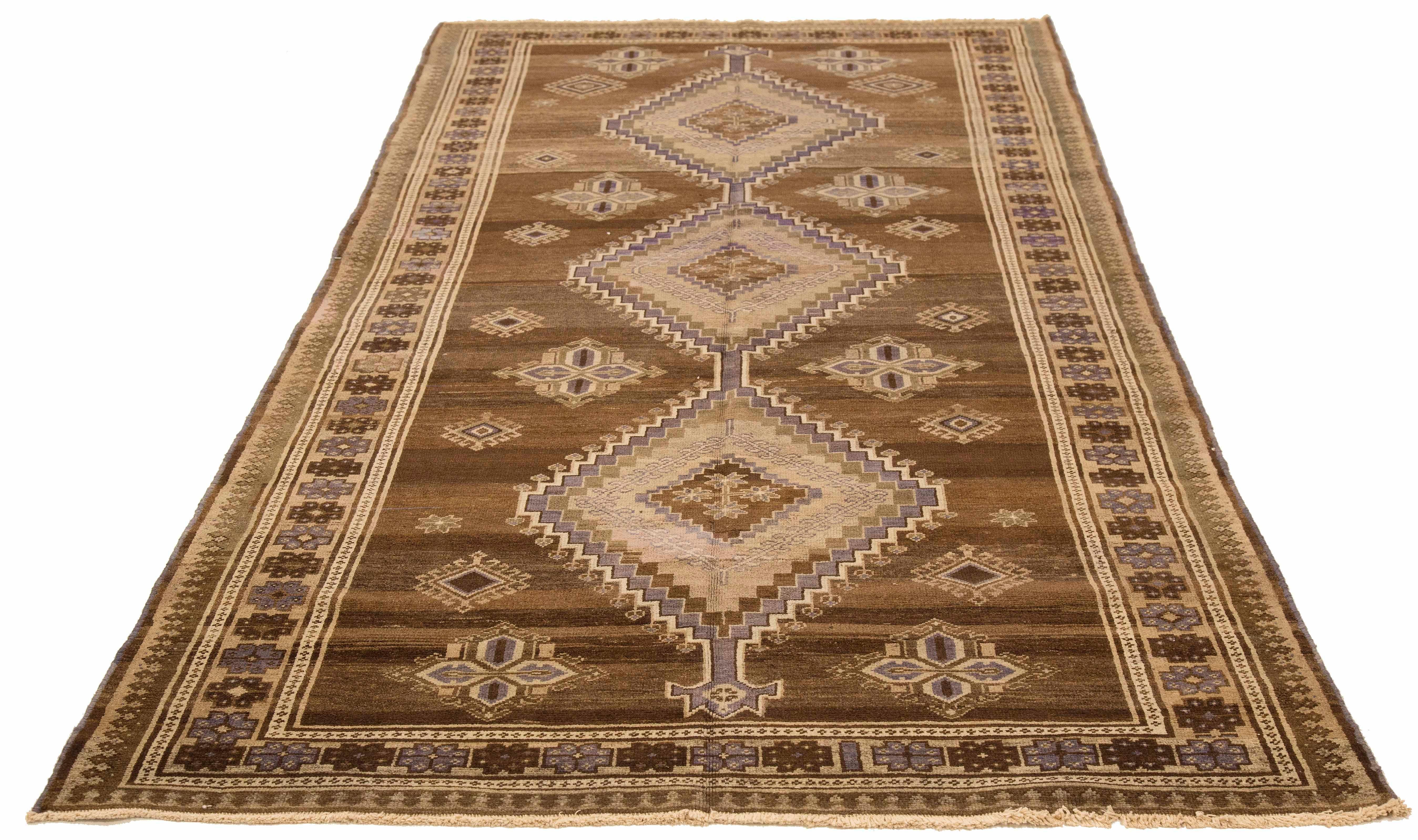 Antique Persian runner rug handwoven from the finest sheep’s wool and colored with all-natural vegetable dyes that are safe for humans and pets. It’s a traditional Malayer design featuring brown and gray geometric details. It’s a lovely piece to
