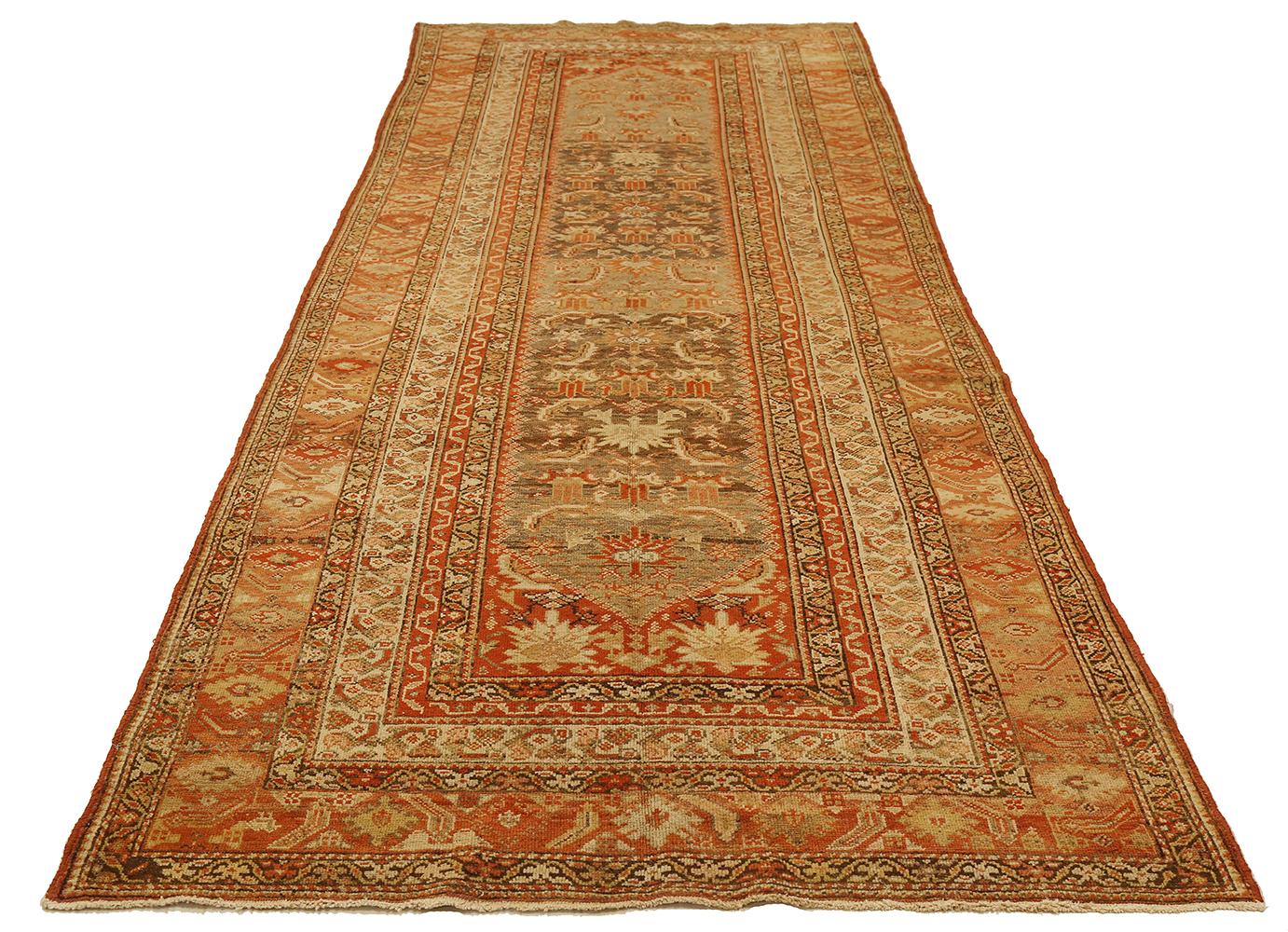 Antique Persian rug handwoven from the finest sheep’s wool and colored with all-natural vegetable dyes that are safe for humans and pets. It’s a traditional Malayer design featuring ivory and brown floral details over a red field. It’s a lovely