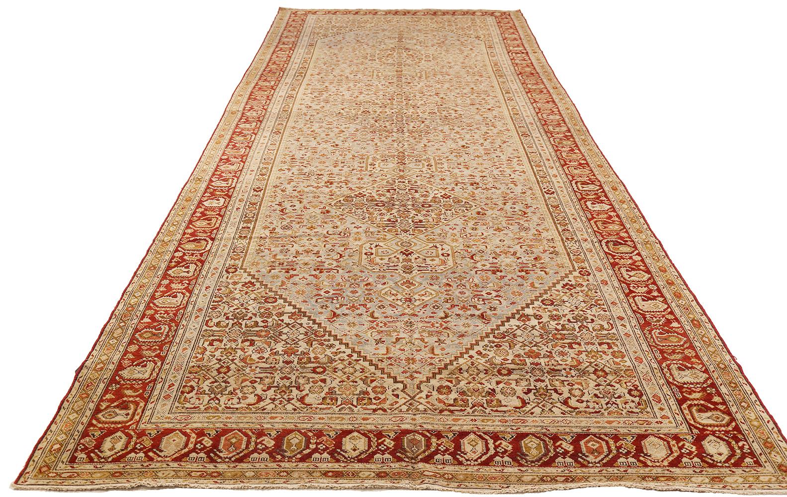 Antique Persian rug handwoven from the finest sheep’s wool and colored with all-natural vegetable dyes that are safe for humans and pets. It’s a traditional Malayer design featuring red and brown floral details over an ivory field. It’s a lovely