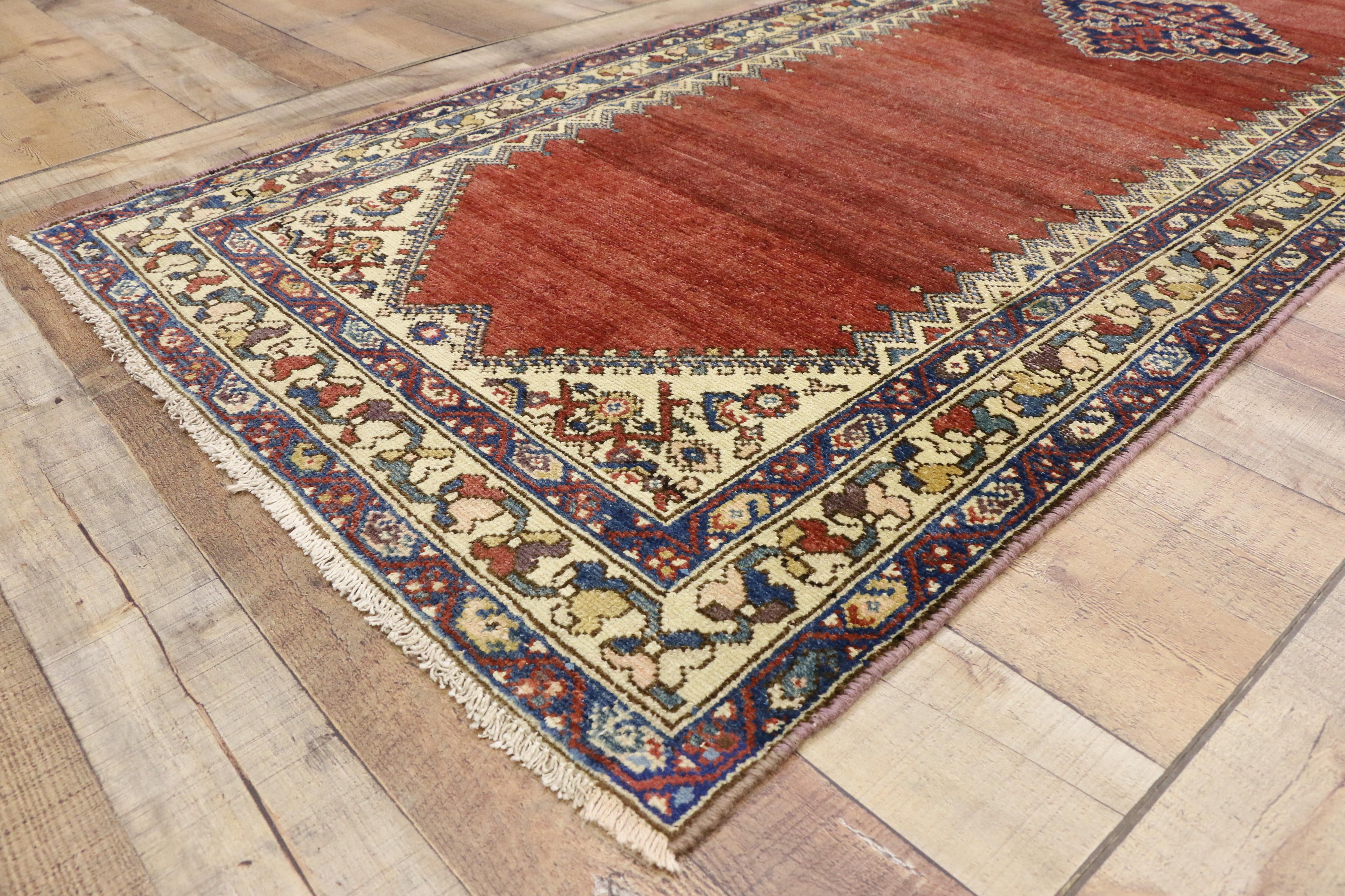76543, antique Persian Malayer runner, hallway runner. This hand knotted wool antique Persian Malayer runner features a stepped lozenge center medallion floating on an abrashed red field. Rows of small pyramids with cruciform tops line the edges,