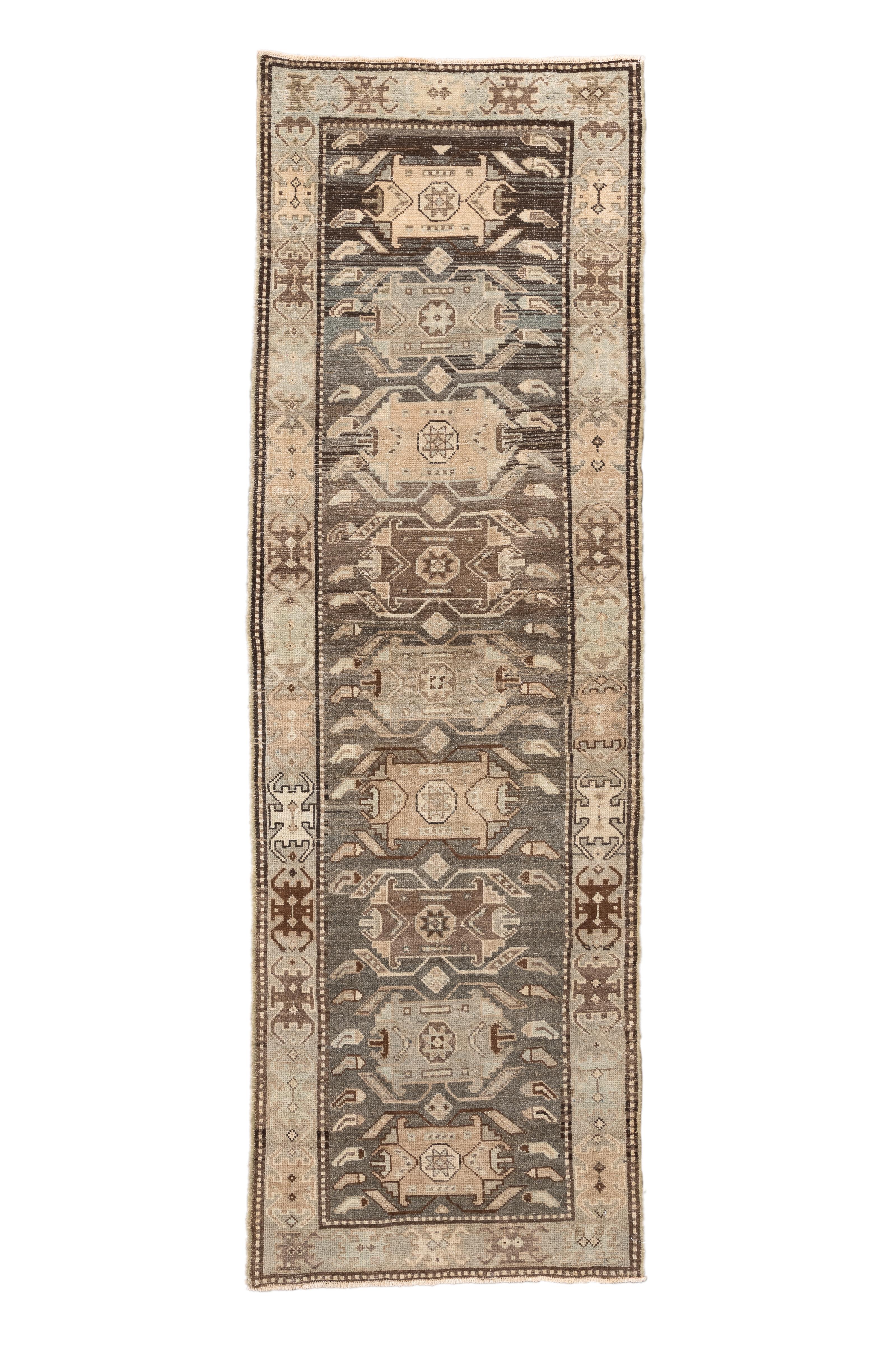  Uno splendido runner persiano antico di Malayer con un motivo geometrico a medaglioni, reso in un'armoniosa tavolozza di marroni morbidi, taupi caldi, blu sbiaditi e avorio cremoso. Questo pezzo esemplifica la raffinata tradizione di tessitura del