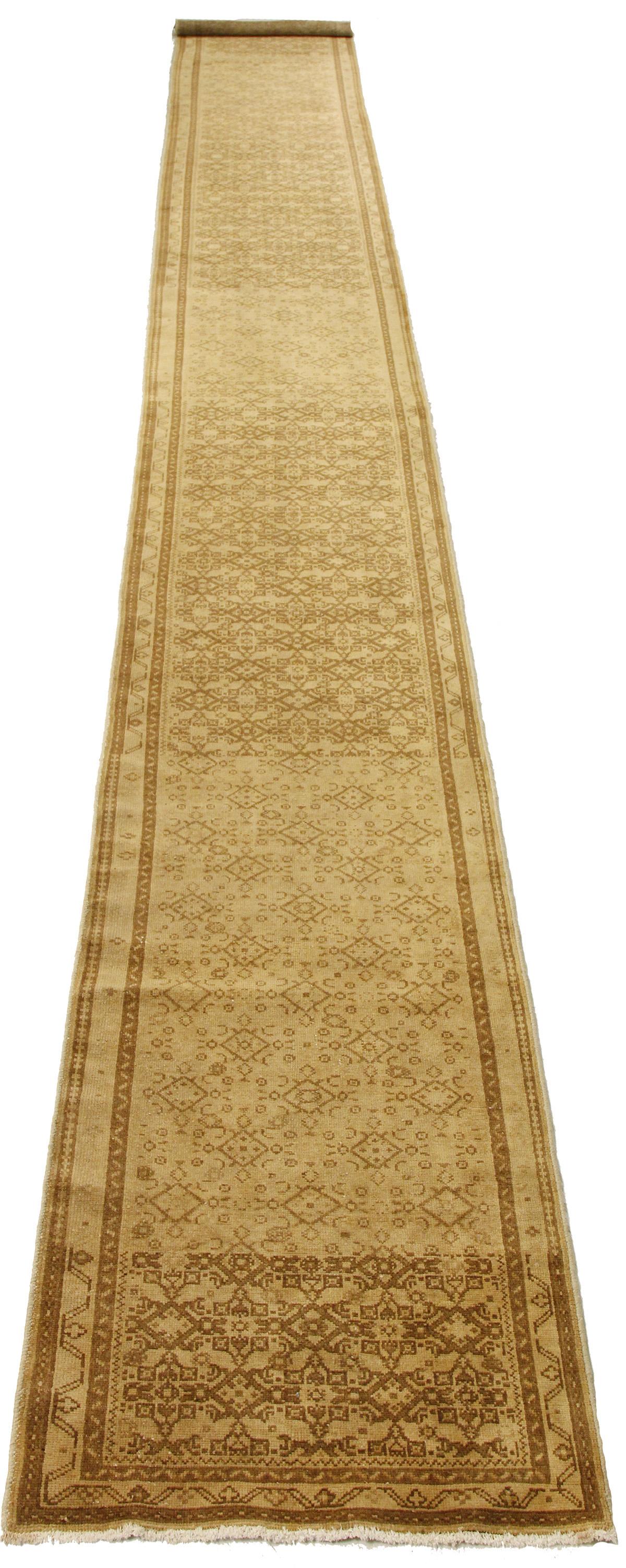 Antique Persian rug handwoven from the finest sheep’s wool and colored with all-natural vegetable dyes that are safe for humans and pets. It’s a traditional Malayer design featuring brown and beige geometric details all-over its field. It’s a lovely