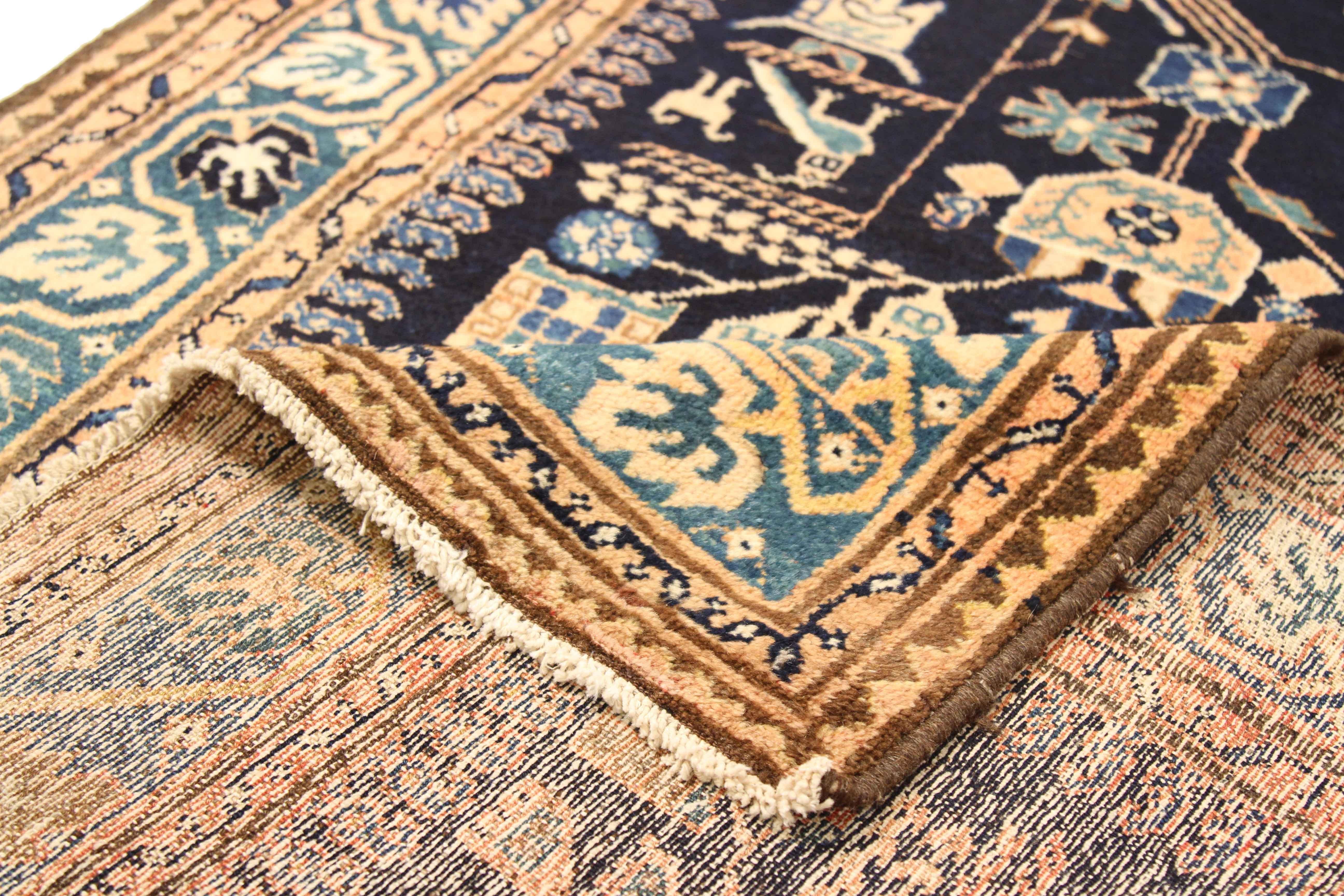 Antique Persian runner rug handwoven from the finest sheep’s wool and colored with all-natural vegetable dyes that are safe for humans and pets. It’s a traditional Malayer design featuring a series of animal and geometric designs in beige, navy blue