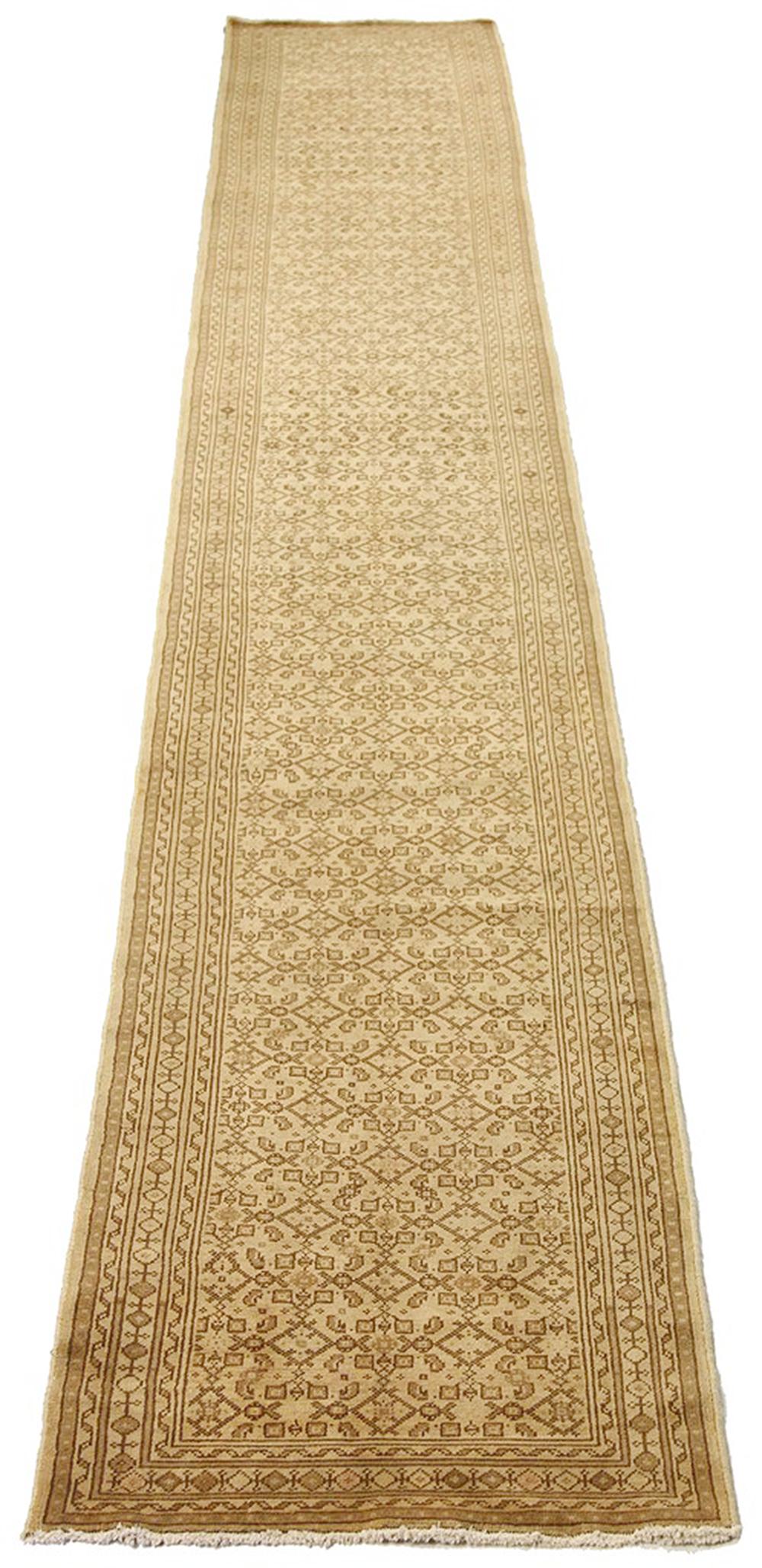Antique Persian runner rug handwoven from the finest sheep’s wool and colored with all-natural vegetable dyes that are safe for humans and pets. It’s a traditional Malayer design featuring beige and brown geometric details over an ivory field. It’s
