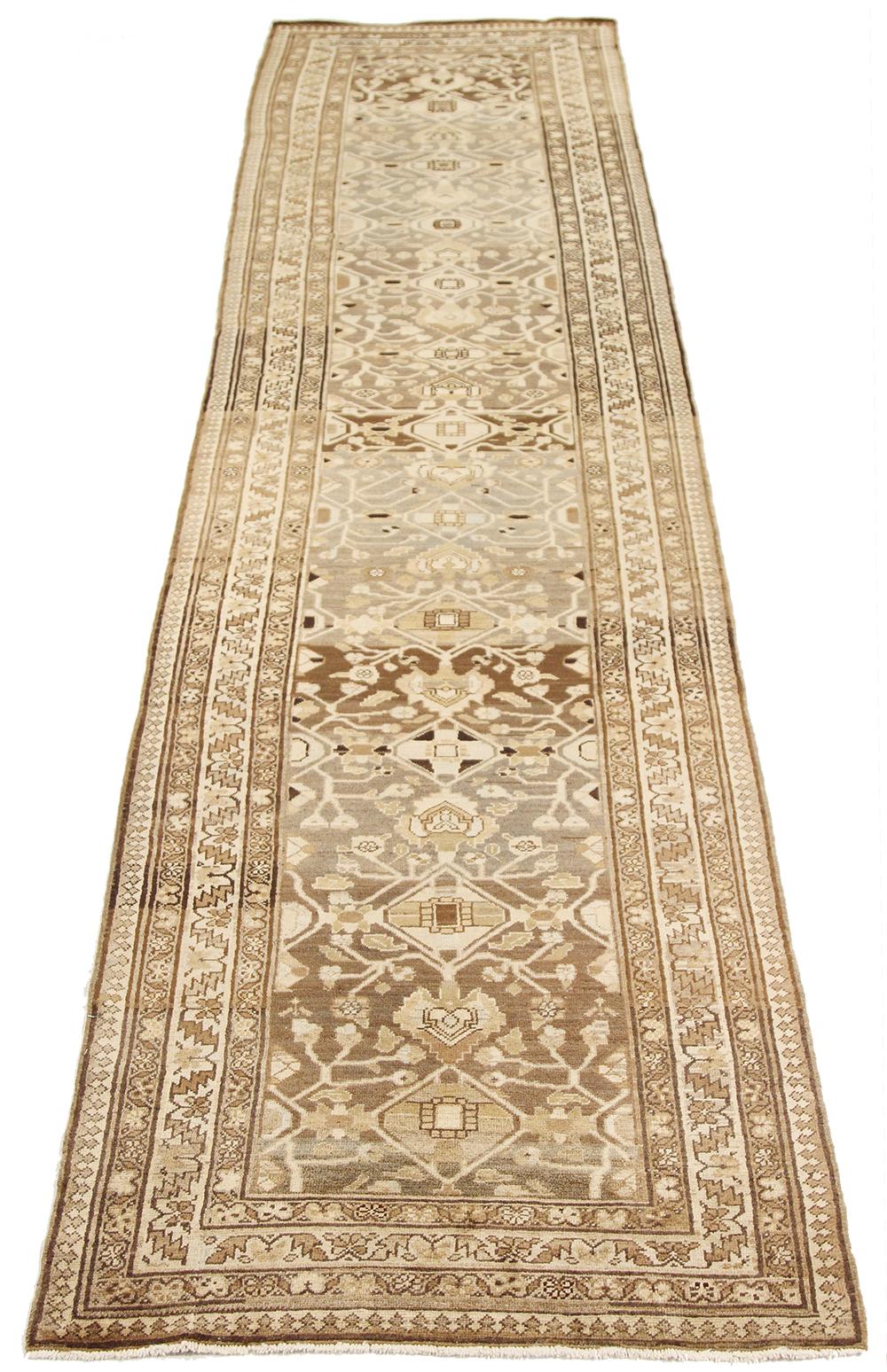 Antique Persian runner rug handwoven from the finest sheep’s wool and colored with all-natural vegetable dyes that are safe for humans and pets. It’s a traditional Malayer design featuring beige and brown tribal details. It’s a lovely piece to