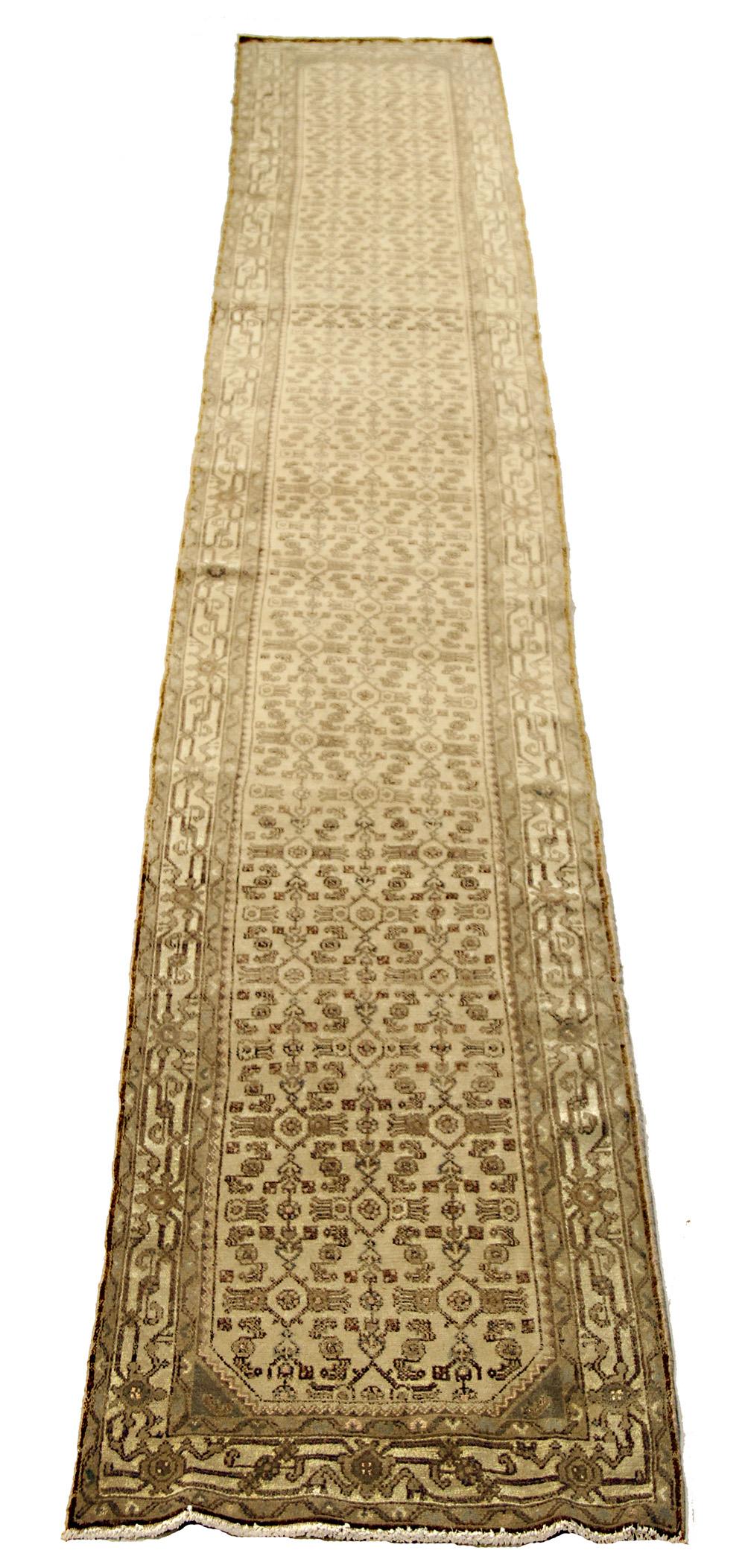 Antique Persian runner rug handwoven from the finest sheep’s wool and colored with all-natural vegetable dyes that are safe for humans and pets. It’s a traditional Malayer design featuring black geometric details over an ivory field. It’s a lovely