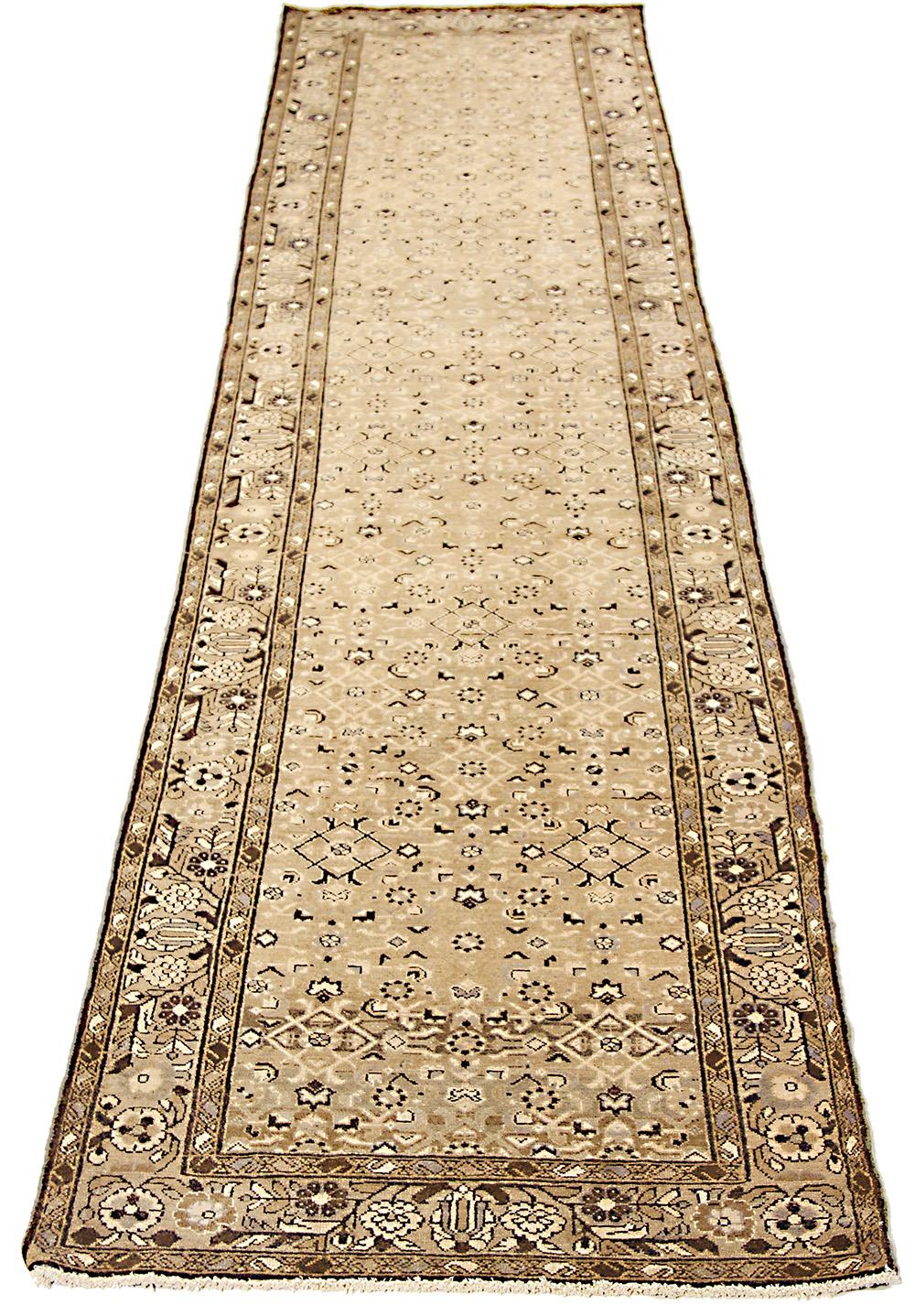Antique Persian runner rug handwoven from the finest sheep’s wool and colored with all-natural vegetable dyes that are safe for humans and pets. It’s a traditional Malayer design featuring black and white botanical patterns over a light brown field.